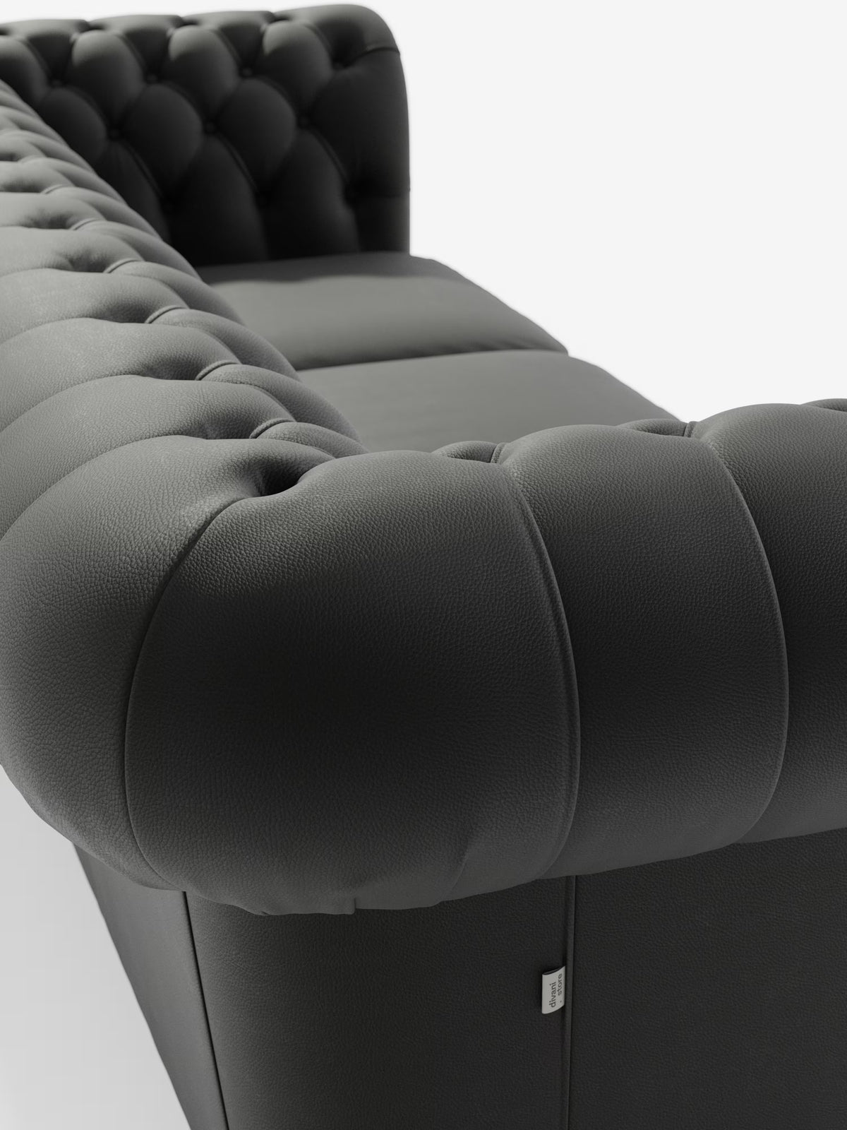 Ecco una versione rielaborata della frase utilizzando i dati del tuo prodotto: Primo piano del Chester 4 Posti 3 sedute in Vera Pelle – Chesterfield Capitonné Artigianale di Divani.Store, realizzato in moderna pelle vera grigio scuro. L’immagine mette in risalto i braccioli e lo schienale trapuntati con profonde cuciture a capitonné, il caratteristico rivestimento testurizzato tipico di un divano Chesterfield, l’imbottitura morbida e una piccola etichetta in tessuto sul lato, il tutto su uno sfondo bianco