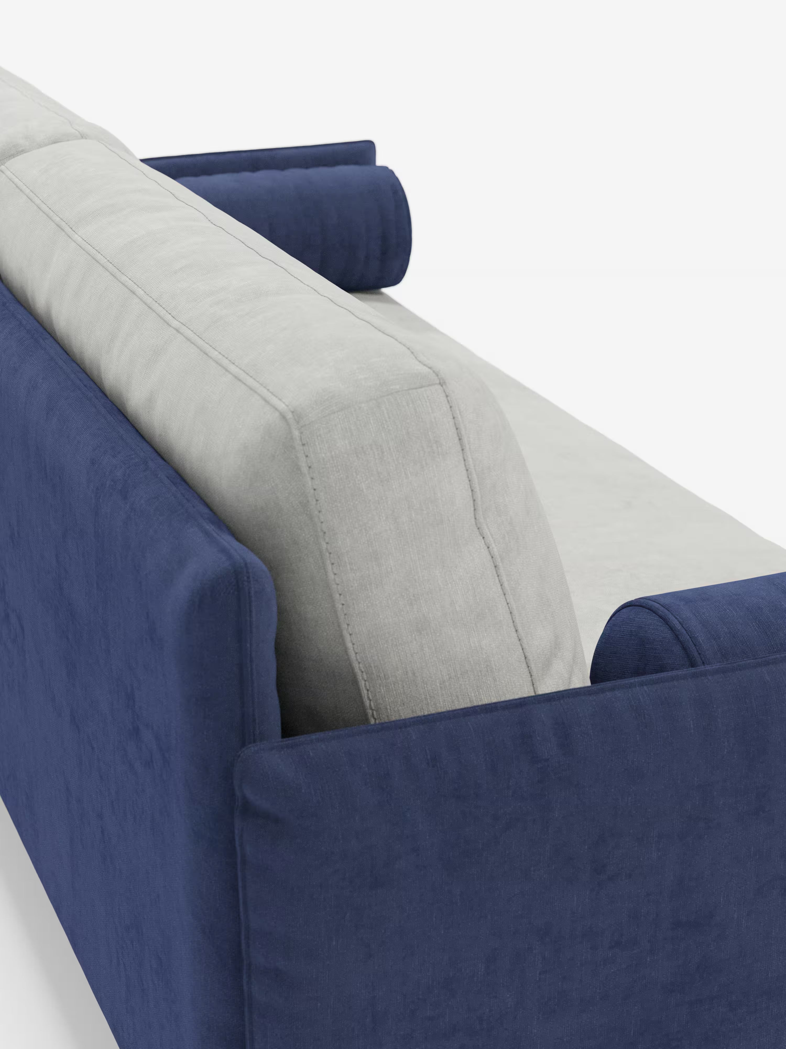 Una vista ravvicinata e angolata del divano Basalto, modello lineare a 2 o 3 posti bicolore con seduta unica e base in metallo, rivestito in tessuto smacchiabile T31 di Divani.Store, caratterizzato da fianchi blu navy e cuscini di seduta e schienale grigio chiaro. Due cuscini cilindrici blu navy sono posizionati alle due estremità dello schienale, mettendo in risalto il design moderno e personalizzabile di questo divano moderno. Lo sfondo è bianco a tinta unita.