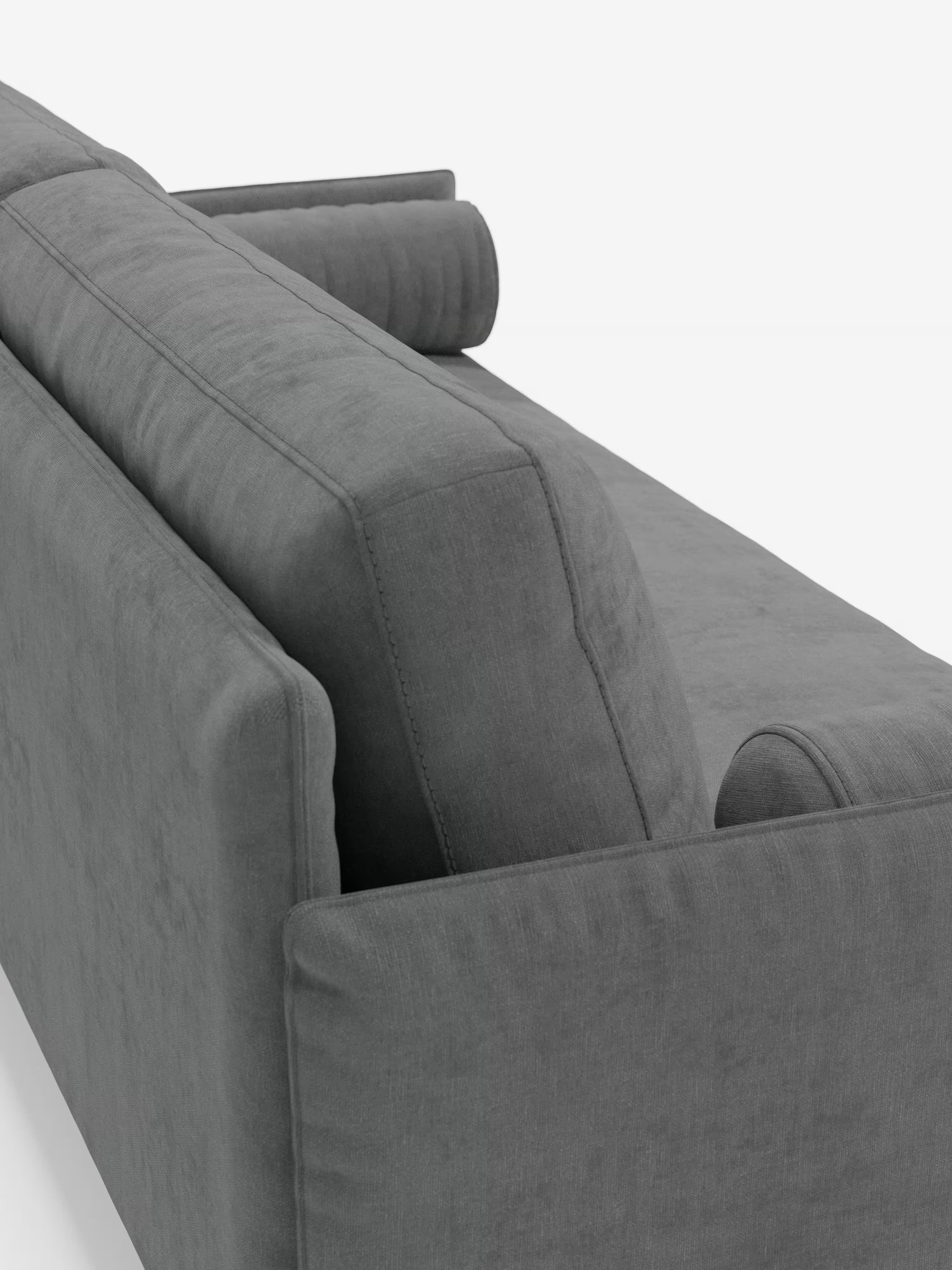 Una vista ravvicinata del retro e del profilo del divano Basalto Divano lineare a 2 o 3 posti con seduta unica e base in metallo, rivestito in tessuto antimacchia T31 di Divani.Store, che ne mette in risalto il design moderno nei toni del grigio, con morbidi cuscini e un cuscino cilindrico sul bracciolo. Il divano è rivestito in tessuto antimacchia e si staglia su uno sfondo bianco a tinta unita.