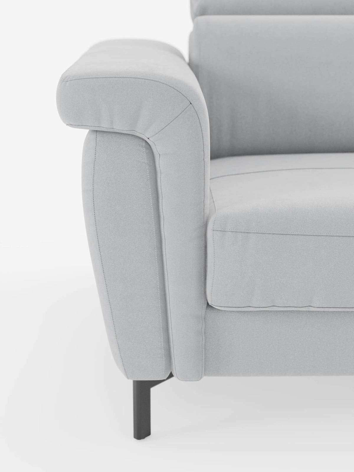 Primo piano del divano letto di design Capri di Divani.Store in grigio chiaro, realizzato in raffinato tessuto effetto velluto T30 resistente alle macchie. L’immagine mette in risalto il bracciolo sinistro, il cuscino di seduta e lo schienale con poggiatesta regolabili. Le linee pulite e l’aspetto morbido e imbottito di questo divano letto sono completati da gambe in metallo scuro e slanciate. Il tutto su uno sfondo bianco e essenziale che ne accentua l’artigianalità italiana e il design raffinato.