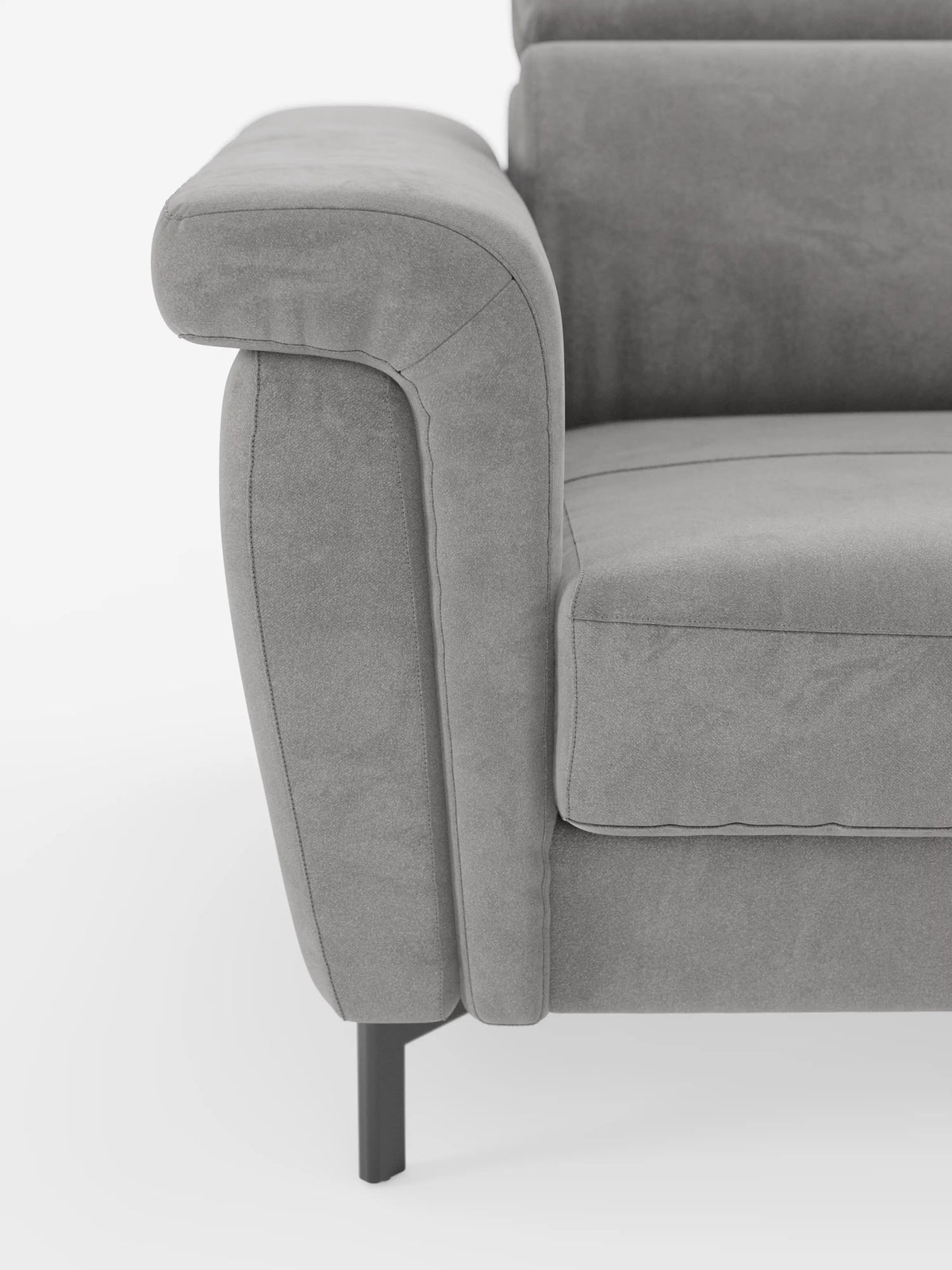 Primo piano del bracciolo sinistro e della seduta del divano letto di design Capri di Divani.Store, caratterizzato da alte gambe in metallo nero, morbido tessuto T30 effetto velluto simile alla pelle scamosciata e smacchiabile, e imbottitura morbida e raffinata con poggiatesta regolabili, ripreso su uno sfondo bianco a tinta unita.