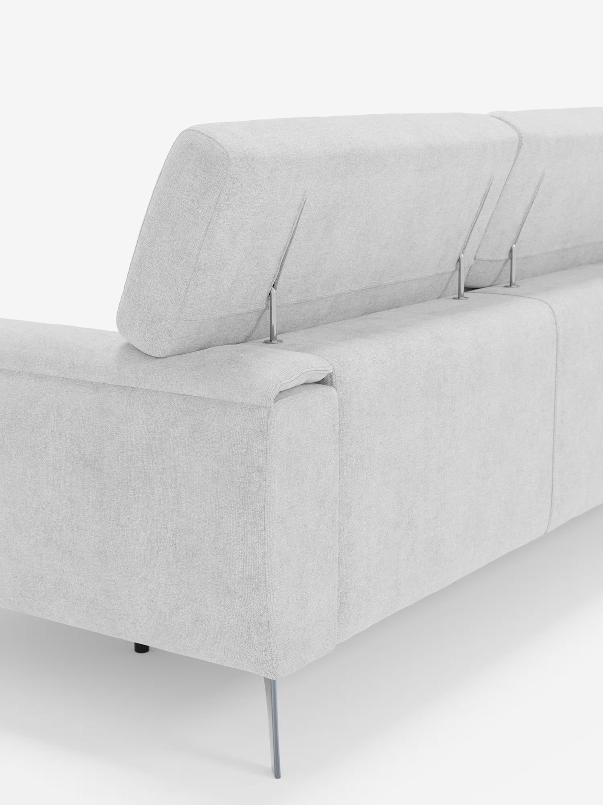 Il divano Caravaggio a 4 posti con tre sedute scorrevoli di Divani.Store è raffigurato di retro, con poggiatesta reclinabili regolabili sostenuti da sottili aste metalliche per un comfort personalizzabile. Questo moderno divano grigio chiaro in tessuto smacchiabile T31 presenta linee pulite e gambe in metallo sottili e affusolate, il tutto su uno sfondo bianco a tinta unita.