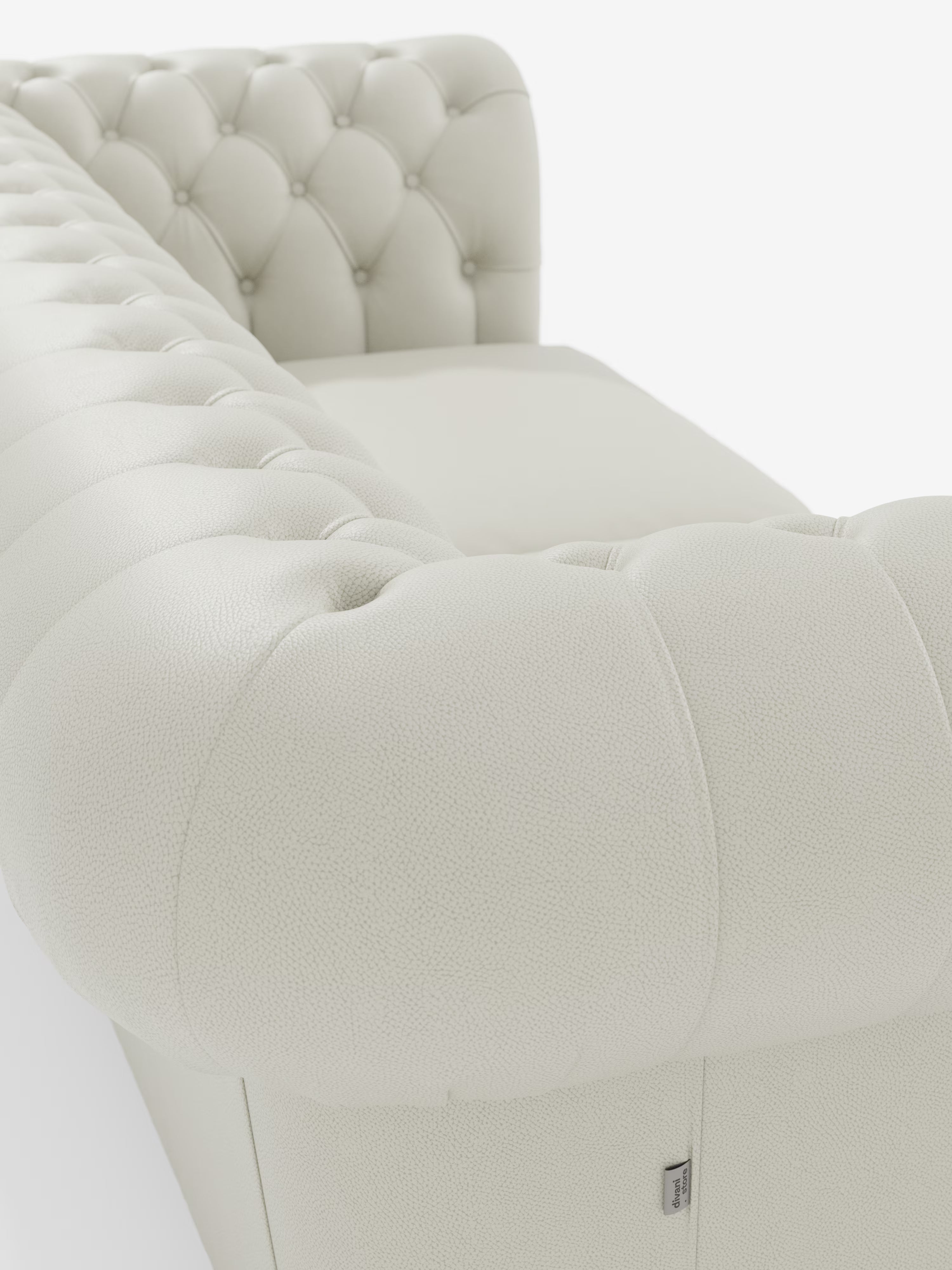 Primo piano del Chester – Divano Chesterfield in vera pelle spessorata a 2 e 3 posti di Divani.Store, caratterizzato da una finitura in pelle bianca trapuntata con braccioli arrotondati e superficie testurizzata. Lo schienale e i braccioli a vista presentano dettagli trapuntati con bottoni e cuciture raffinate. Realizzato come divano artigianale italiano (Made in Italy) e rivestito in vera pelle pieno fiore di alta qualità, il design lussuoso e classico di questo modello risalta sullo sfondo bianco a tinta