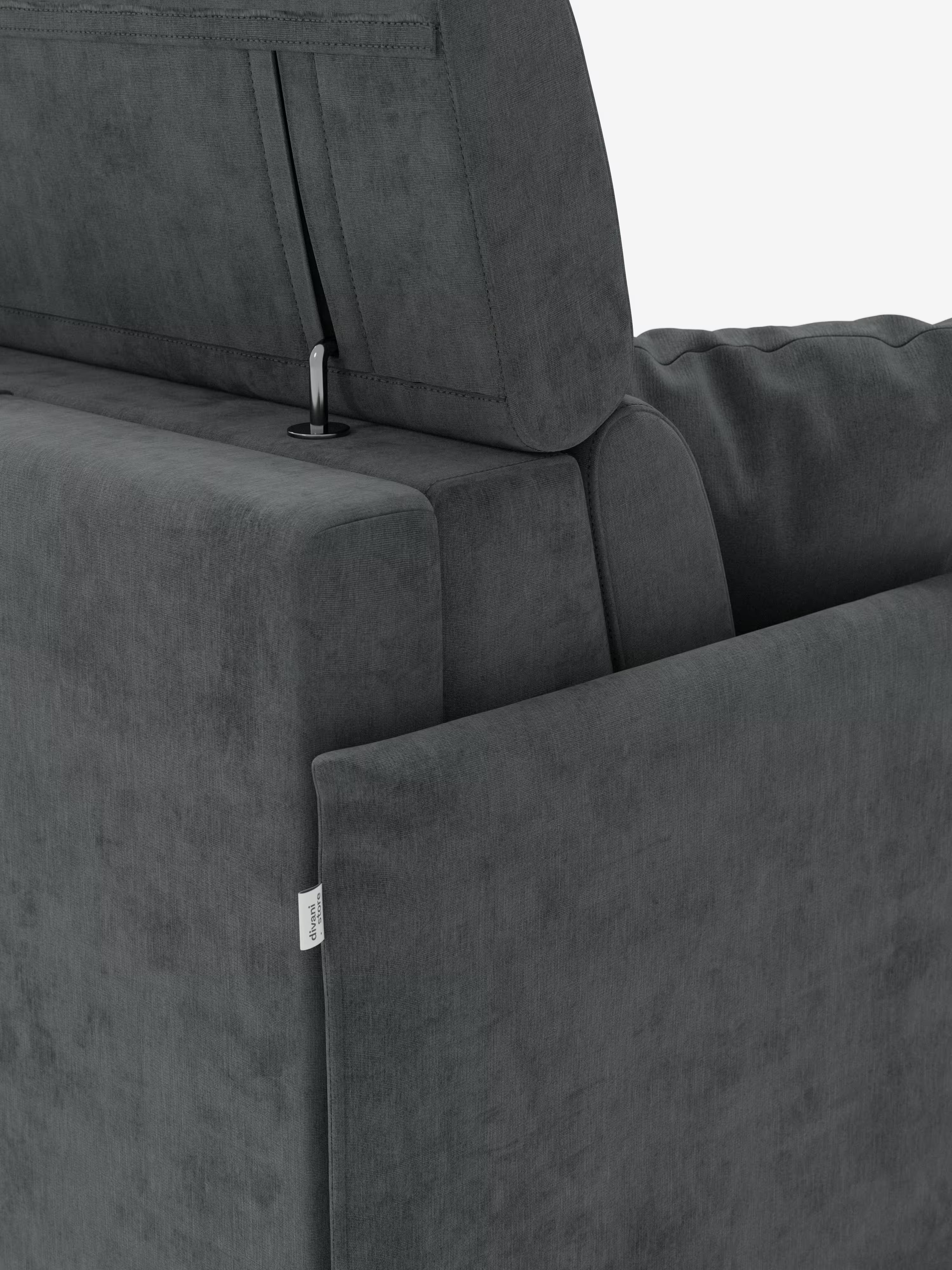 Un primo piano del divano letto Miryam con poggiatesta reclinabili e comfort maxi di Divani.Store ne mette in risalto la moderna finitura imbottita in grigio scuro, caratterizzata da un design compatto e contemporaneo, con poggiatesta regolabili dotati di cerniere a vista e una discreta etichetta in tessuto bianco sul lato, il tutto su uno sfondo bianco a tinta unita.