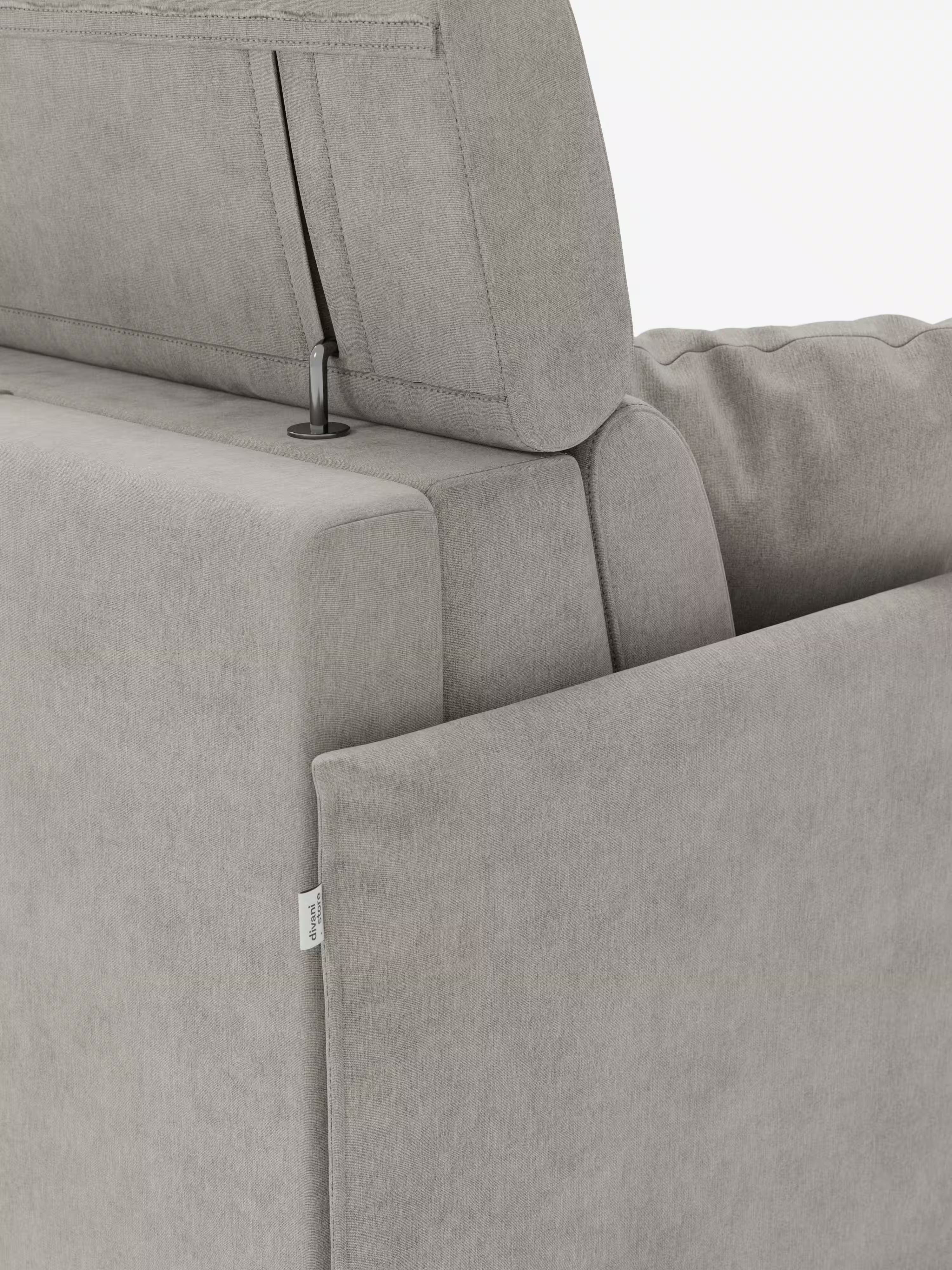 Primo piano del divano letto Miryam con poggiatesta reclinabili e comfort maxi di Divani.Store, realizzato in tessuto T31 grigio chiaro facile da pulire, che mette in risalto lo schienale, il poggiatesta leggermente rialzato e regolabile (poggiatesta reclinabili) e parte del bracciolo. Sulla cucitura laterale è visibile una piccola etichetta in tessuto bianco. L’aspetto complessivo è moderno e incarna uno stile minimal contemporaneo grazie al suo design compatto.