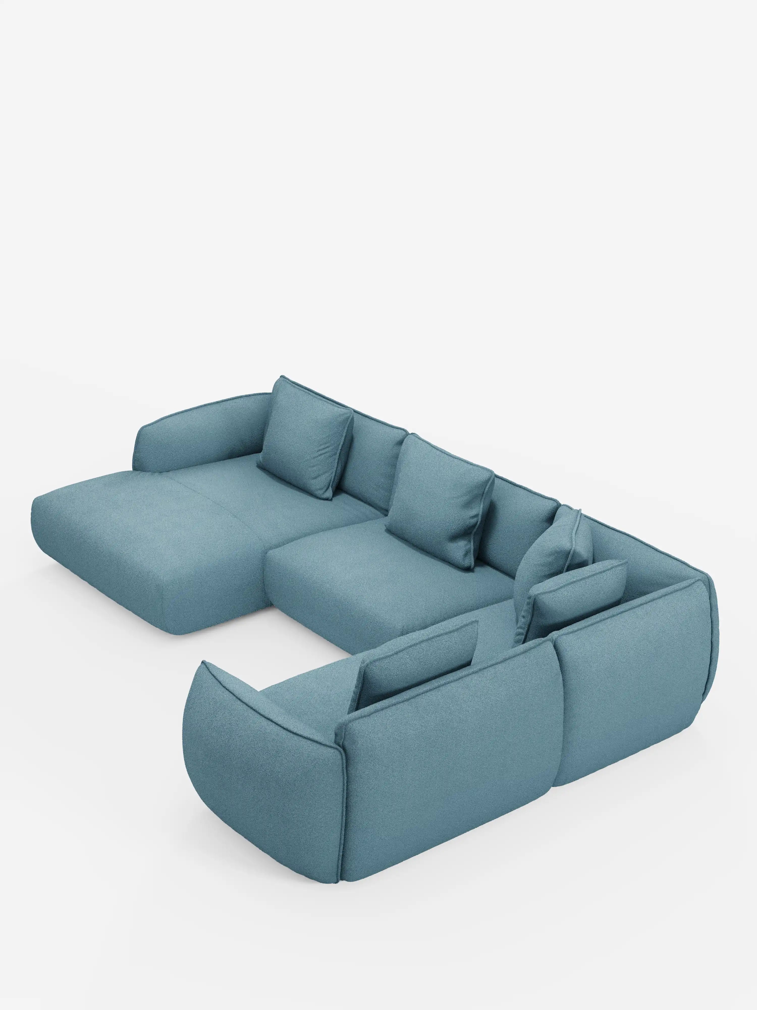 Il divano angolare panoramico componibile Nimbus con penisola e angolo in tessuto smacchiabile T33 di Divani.Store è un divano modulare contemporaneo di colore azzurro, caratterizzato da schienali bassi, ampi braccioli e cinque cuscini rettangolari coordinati, disposti con eleganza a forma di L su uno sfondo bianco a tinta unita.