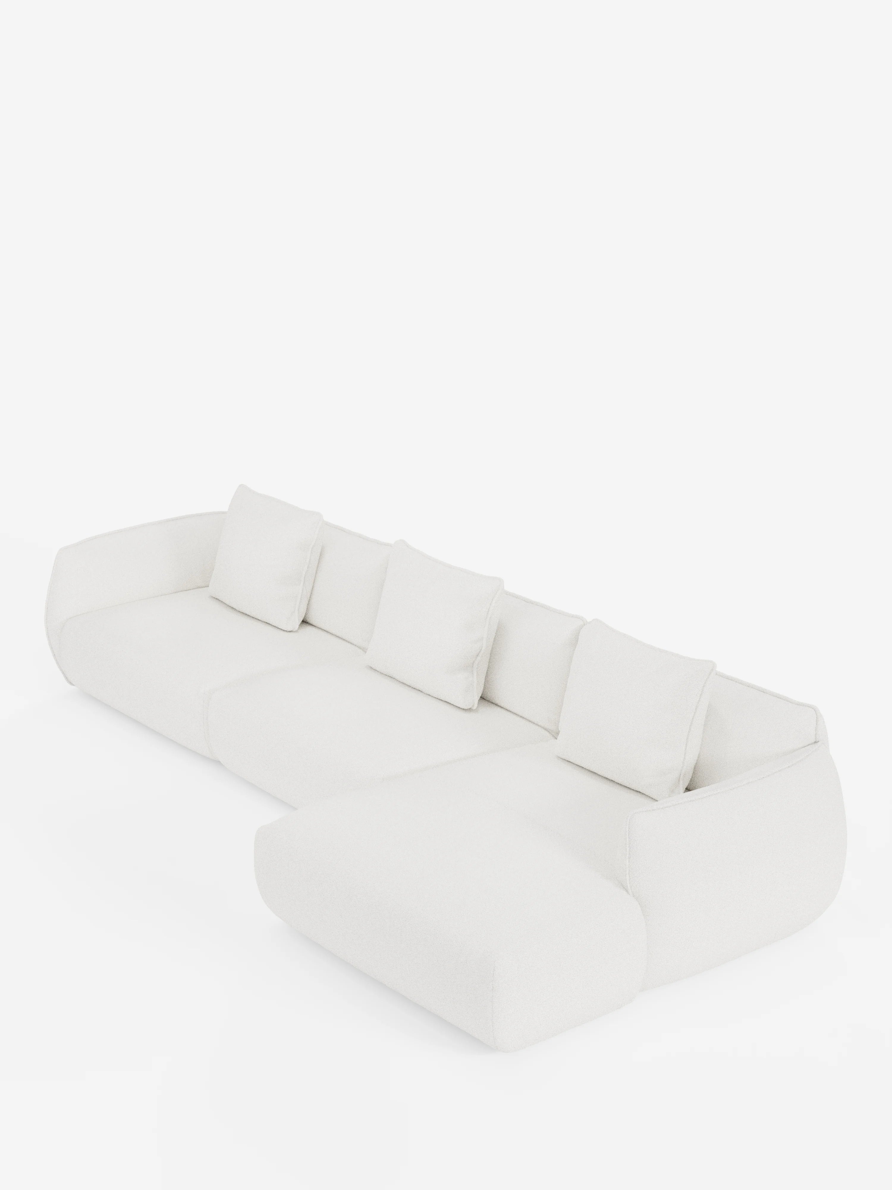 Il divano angolare con penisola componibile Nimbus di Divani.Store è un divano componibile moderno, di colore bianco, realizzato in morbido tessuto effetto cotone resistente alle macchie (T33), dotato di quattro cuscini dello schienale, ampi braccioli e una chaise longue allungata sul lato sinistro, raffigurato su uno sfondo bianco a tinta unita.