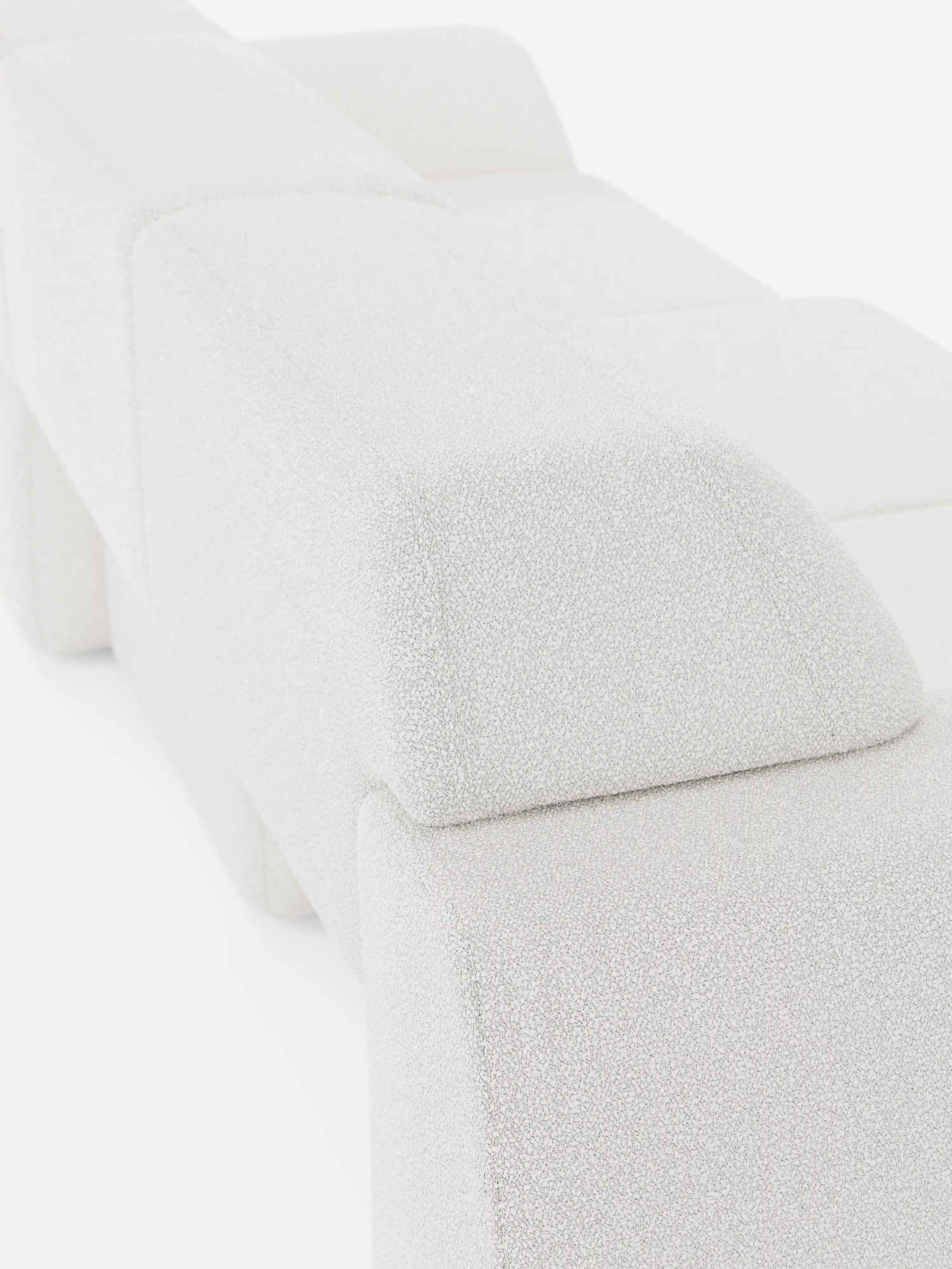 Una vista ravvicinata e obliqua del divano Orbit con 3 sedute scorrevoli e allungabili in tessuto effetto cotone smacchiabile T33 di Divani.Store, caratterizzato da forme geometriche moderne e cuscini squadrati. L'immagine mette in risalto le linee pulite del divano, il tessuto morbido dall'effetto cotone, e ne esalta il design completamente sfoderabile su uno sfondo bianco a tinta unita.