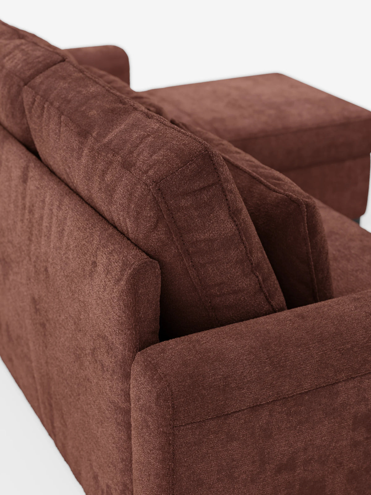 Una vista dall'alto di un divano letto Ottaviano con letto estraibile - penisola reversibile e contenitore in tessuto materico smacchiabile, caratterizzato da un tessuto marrone testurizzato, braccioli squadrati, cuscini dello schienale spessi e una chaise longue.