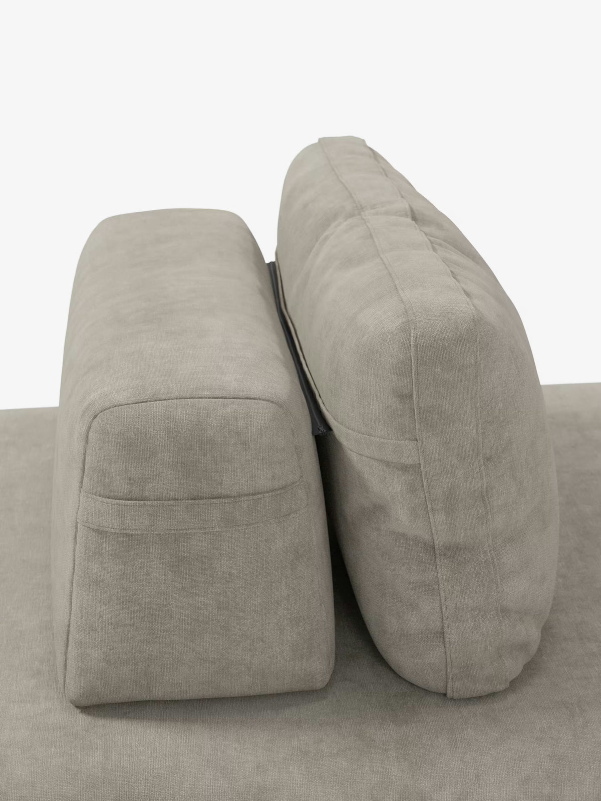 Due cuscini rettangolari di colore grigio chiaro sono disposti in posizione verticale sulla base abbinata del divano letto matrimoniale Rift a 2 e 3 posti con schienali mobili di Divani.Store. Il cuscino di sinistra è leggermente più alto e dalla forma più squadrata, mentre quello di destra, dotato di schienale mobile, presenta un aspetto più arrotondato e morbido. Lo sfondo è bianco a tinta unita.