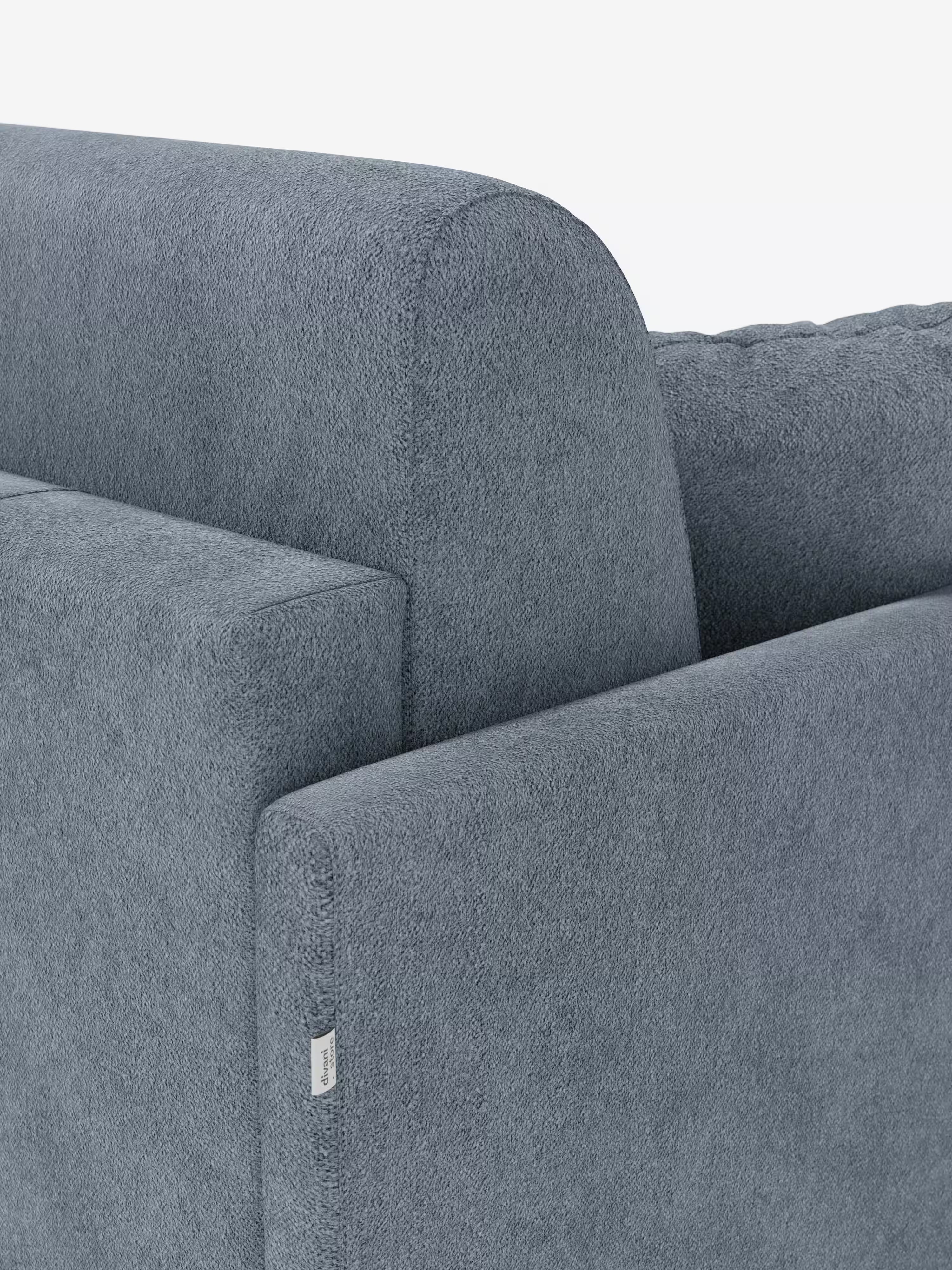 Primo piano dello schienale e del bracciolo del divano letto Tommy a 2 e 3 posti matrimoniale di Divani.Store, rivestito in tessuto T33 grigio, effetto cotone testurizzato. Questo divano, sfoderabile al 100%, presenta braccioli sottili e una piccola etichetta in tessuto bianco cucita vicino al bordo del bracciolo. L'immagine mette in risalto le linee pulite e dritte e il rivestimento morbido e resistente alle macchie.