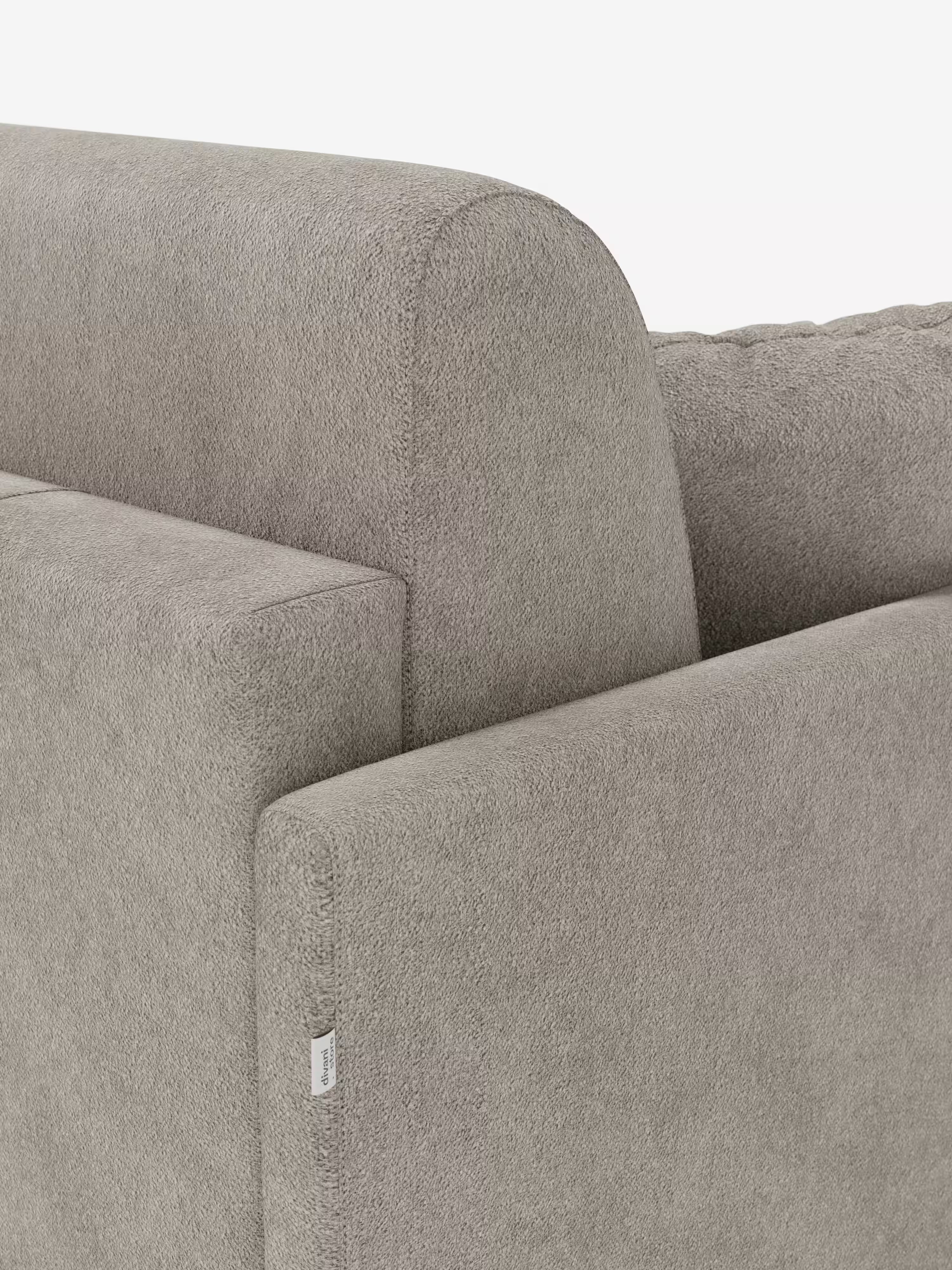 Primo piano del divano letto Tommy a 2 e 3 posti matrimoniale di Divani.Store, rivestito in tessuto T33 effetto cotone grigio chiaro e resistente alle macchie. L’immagine mette in risalto lo schienale e i braccioli sottili dai bordi netti e squadrati, sottolineando il design slanciato dei braccioli che esalta la sua silhouette moderna. Una piccola etichetta in tessuto è applicata sulla cucitura laterale. Sullo sfondo bianco a tinta unita, risaltano la trama del divano e la sua estetica contemporanea.