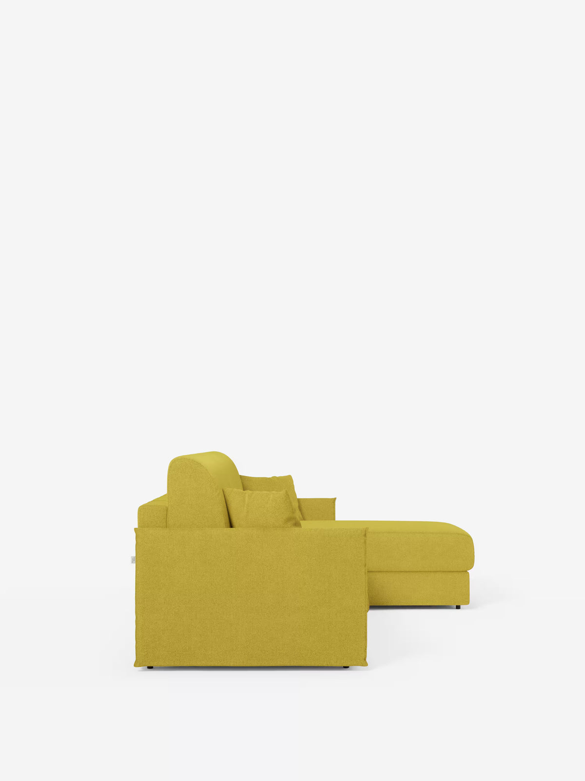 Vista laterale del divano letto angolare con penisola contenitore Evans di Divani.Store, caratterizzato da linee pulite e rivestito in un moderno tessuto giallo senape (tessuto smacchiabile T23). Il design compatto comprende una chaise longue sul lato destro con vano contenitore integrato e due cuscini coordinati appoggiati sulla seduta. Sullo sfondo bianco a tinta unita, l’estetica contemporanea e minimalista del divano risalta in modo particolare.