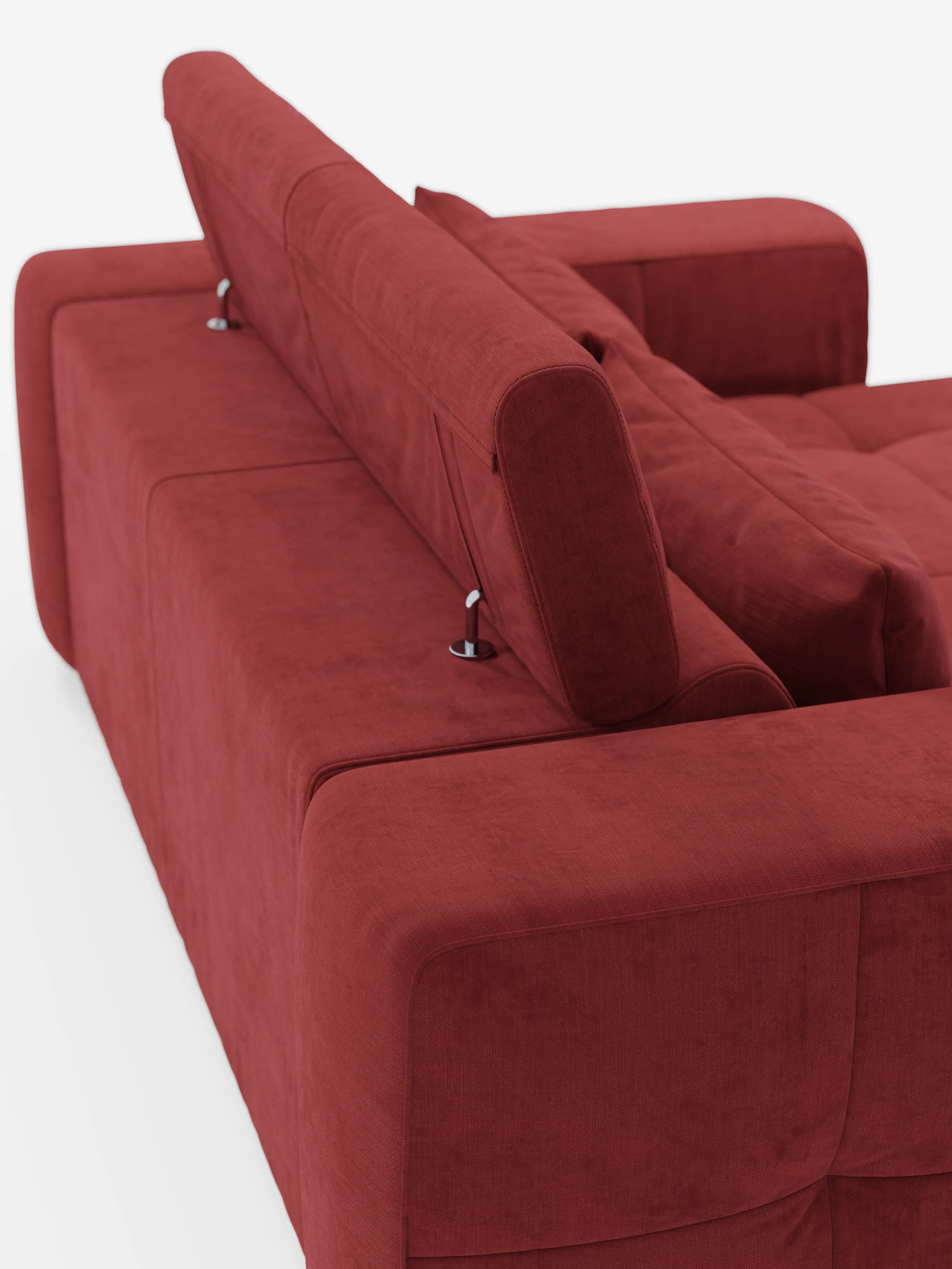 Un divano contemporaneo rosso “Monarch” con funzione relax elettrica per l’allungamento delle sedute e poggiatesta reclinabile in morbido tessuto lavabile T31 di Divani.Store è ripreso di spalle da un’angolazione obliqua. Il poggiatesta in posizione verticale, sostenuto da eleganti cerniere in metallo, e i cuscini morbidi e soffici evocano una sensazione di comfort che ricorda quella di un classico divano relax elettrico. L’ambientazione minimalista è caratterizzata da uno sfondo bianco brillante.