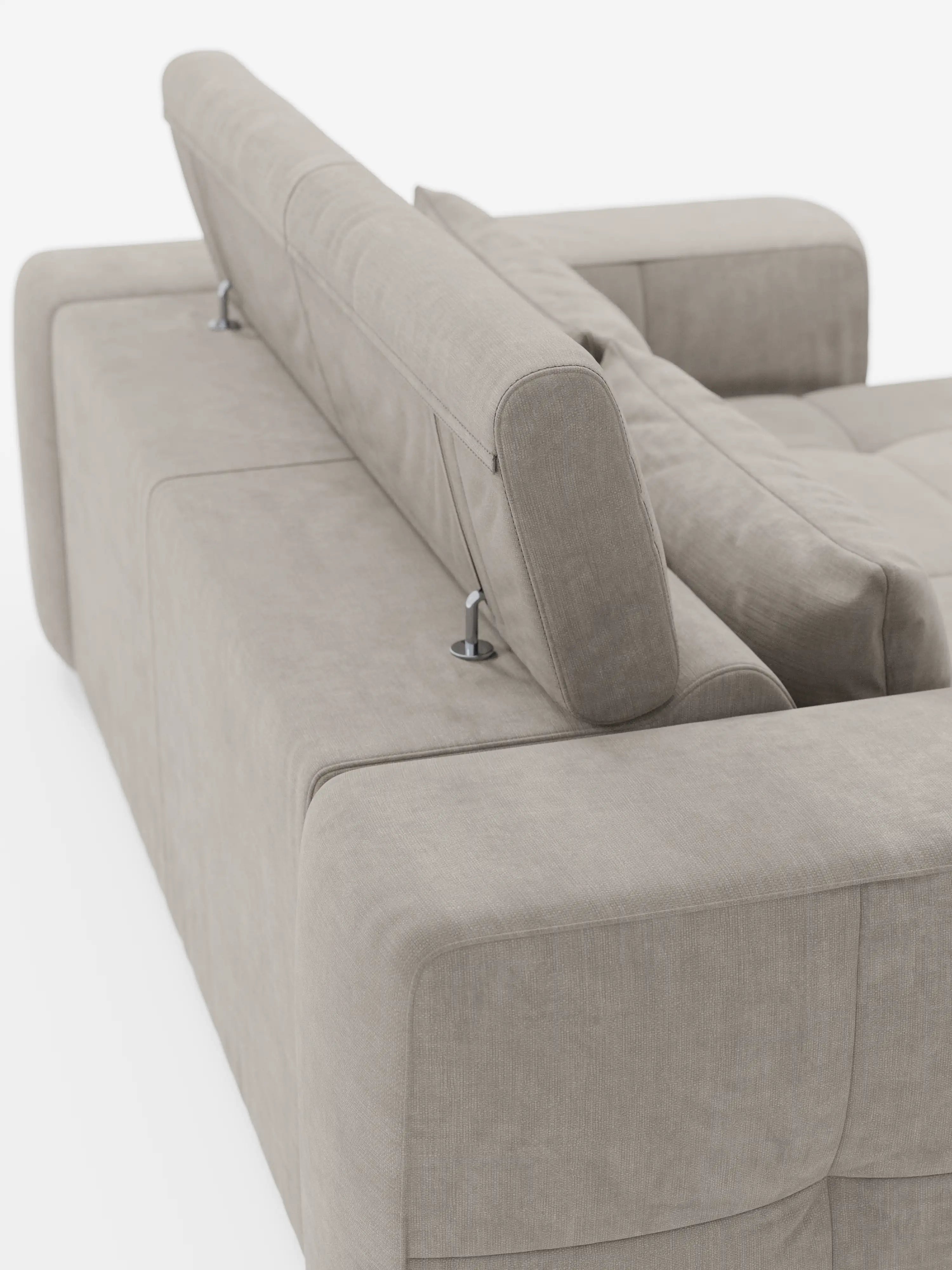 Un divano Monarch color beige chiaro con funzione relax elettrica per l'allungamento delle sedute e poggiatesta reclinabile, rivestito in morbido tessuto smacchiabile T31 di Divani.Il divano è ripreso da dietro e presenta un ampio bracciolo, cuciture a vista e un poggiatesta regolabile sostenuto da staffe metalliche, il tutto su uno sfondo bianco: un elegante esempio di design italiano contemporaneo.