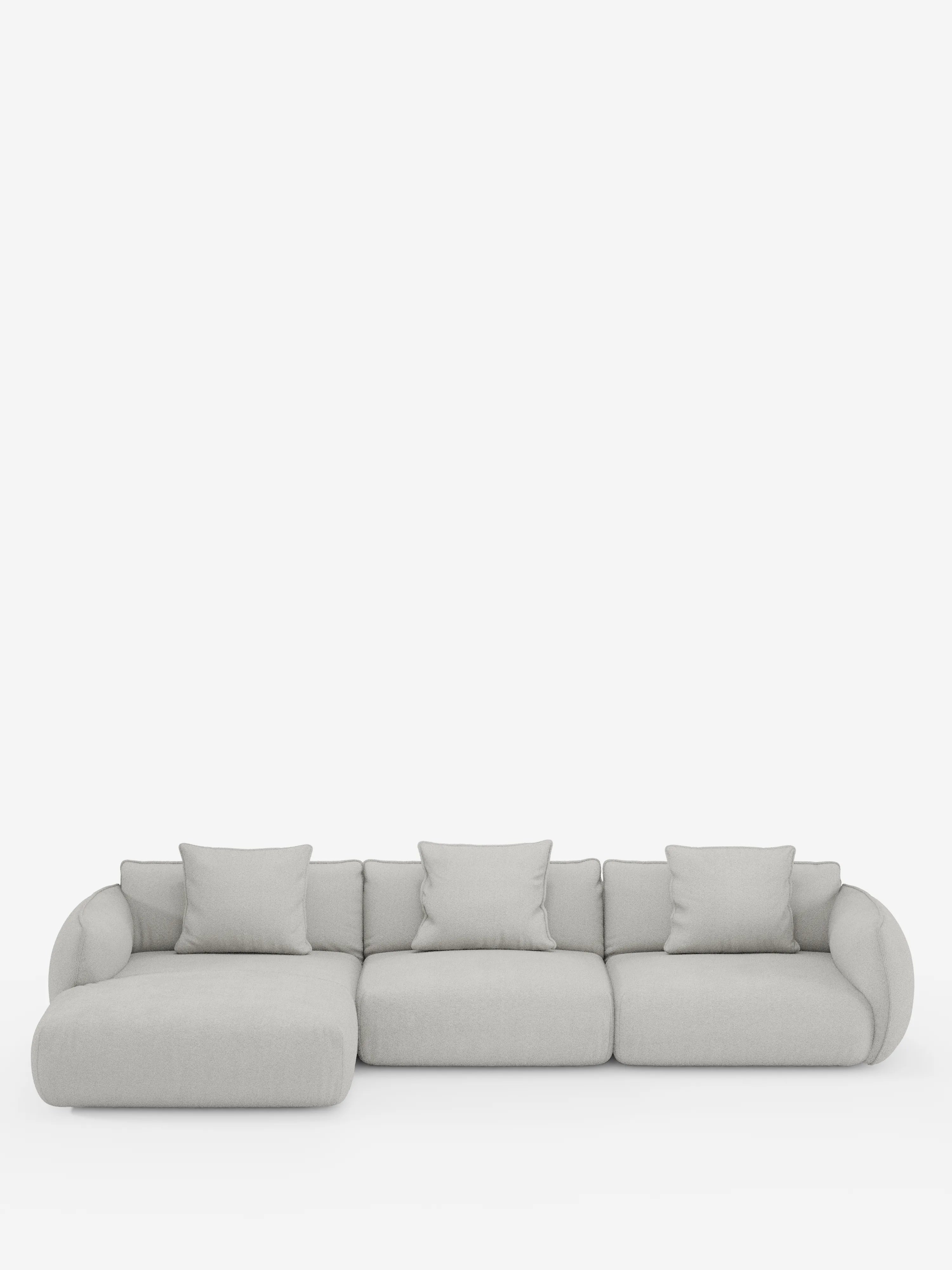 Un divano angolare contemporaneo Nimbus con penisola componibile, realizzato in morbido tessuto effetto cotone smacchiabile T33 di Divani.Store, rivestito in grigio chiaro, spicca su uno sfondo bianco a tinta unita. Il divano componibile presenta tre posti principali, una chaise longue che si estende verso sinistra, cinque cuscini coordinati, braccioli arrotondati e si caratterizza per un design morbido e minimalista.