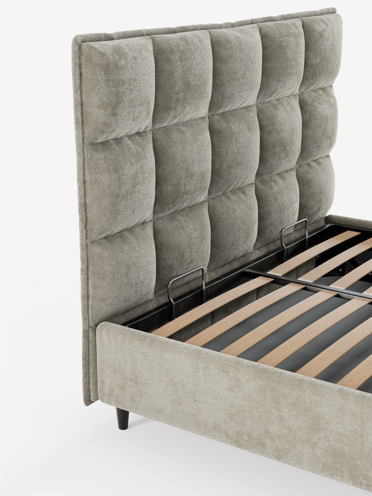 Un primo piano del letto imbottito con contenitore AURO di Letti.store, che mette in risalto la sua alta testiera capitonné rivestita in morbida ciniglia Oeko-Tex®, sostenuta da corte gambe nere e da due staffe metalliche nere alla base che garantiscono un maggiore sostegno al materasso.