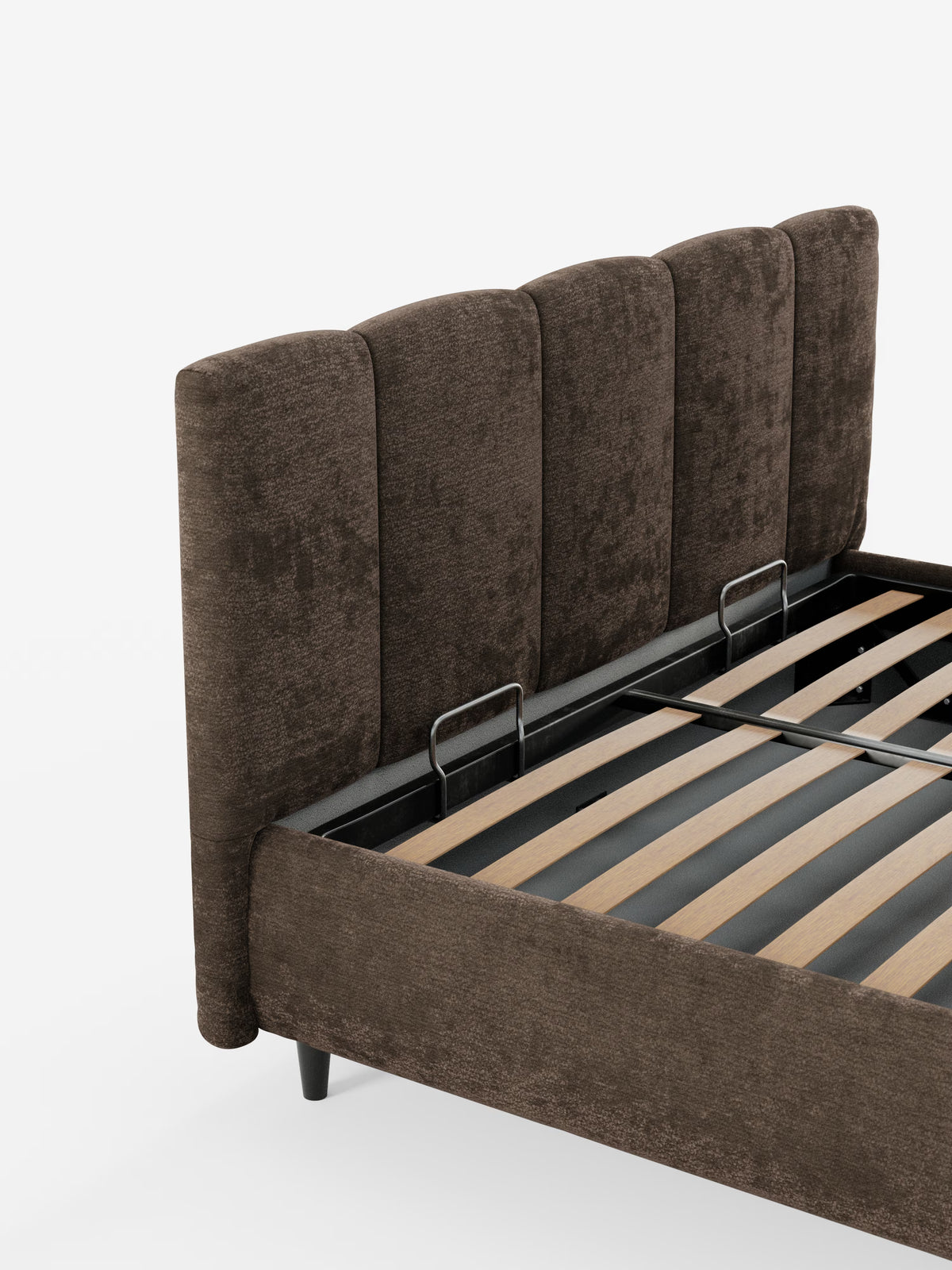 Un primo piano del letto imbottito ARKAM con contenitore e testiera a cuciture verticali di Letti.store mette in risalto una struttura del letto rivestita in marrone con una testiera alta, caratterizzata da cuciture verticali, realizzata in tessuto certificato Oeko-Tex®. Questo letto moderno in stile shabby chic presenta doghe in legno a vista, due barre di sostegno in metallo e poggia su gambe corte e scure su uno sfondo bianco a tinta unita.