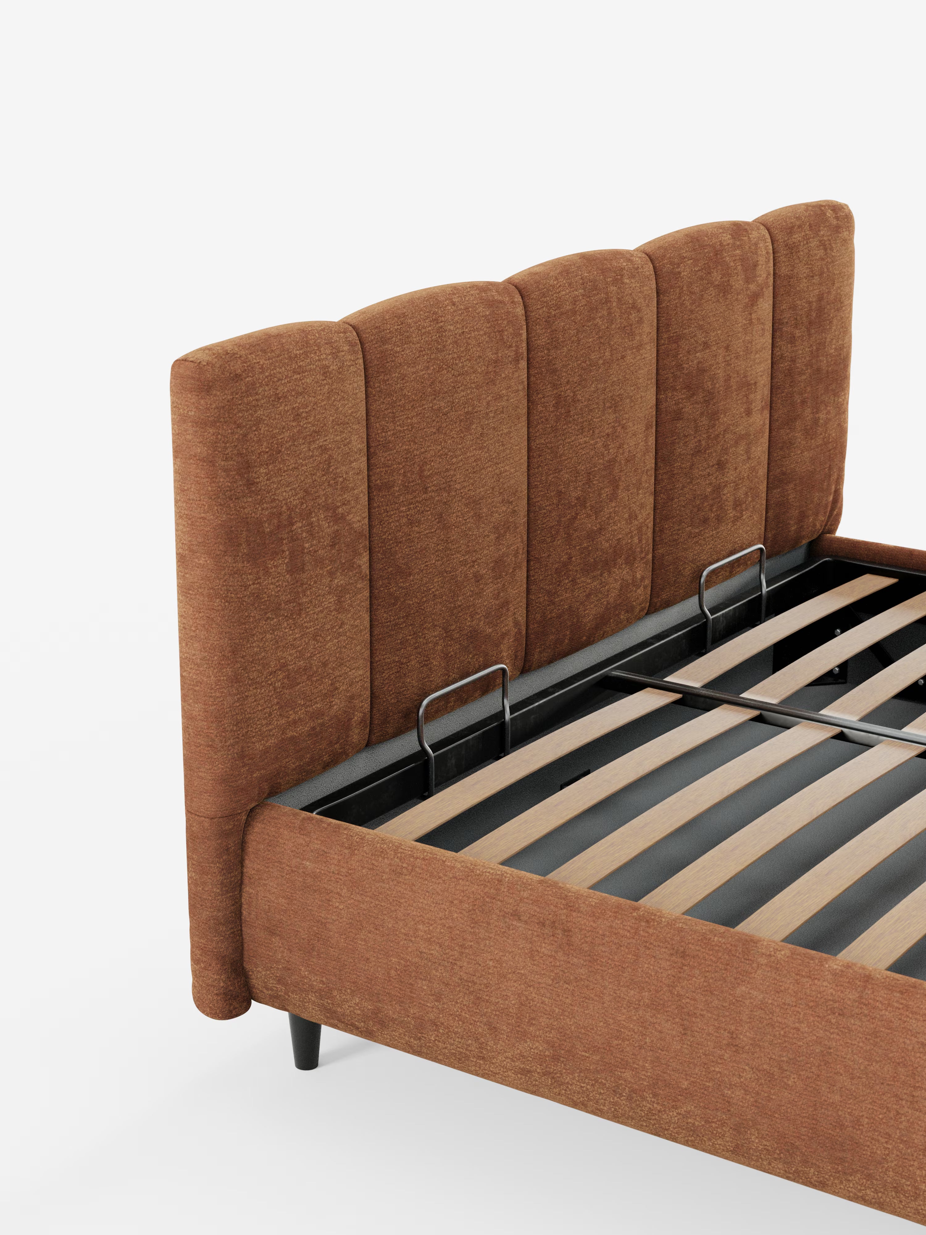 Un primo piano del letto imbottito ARKAM con contenitore e testiera a cuciture verticali di Letti.store mostra una testiera alta e imbottita, con cuciture verticali, rivestita in tessuto marrone certificato Oeko-Tex® e doghe in legno a vista. Il telaio è attraversato da supporti in metallo nero. Il letto in stile shabby chic poggia su gambe nere corte e angolate ed è raffigurato su uno sfondo bianco.