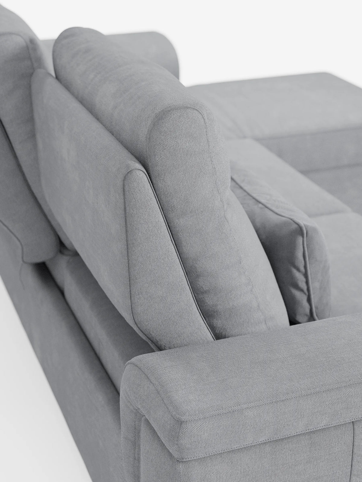 Una veduta dall'alto di un divano letto angolare Ischia di colore grigio chiaro, dotato di schienali scorrevoli, elemento estraibile e penisola contenitore in tessuto antimacchia misto lino, con cuscini verticali e una chaise longue contenitore, davanti a una parete bianca.