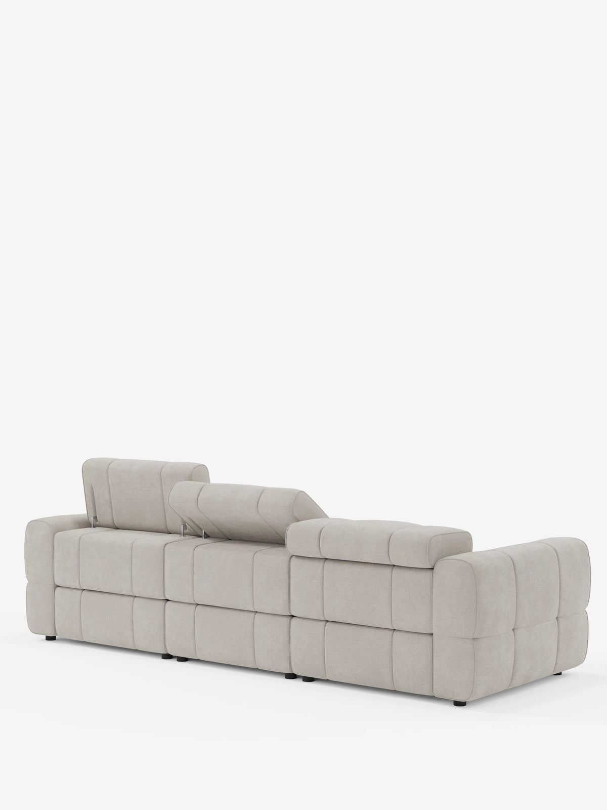 Un divano modulare Giotto a quattro posti color beige chiaro, con poggiatesta reclinabili e funzione relax elettrica opzionale, rivestito in tessuto smacchiabile T23, ripreso da dietro, caratterizzato da un motivo trapuntato e da poggiatesta regolabili su uno sfondo bianco a tinta unita.