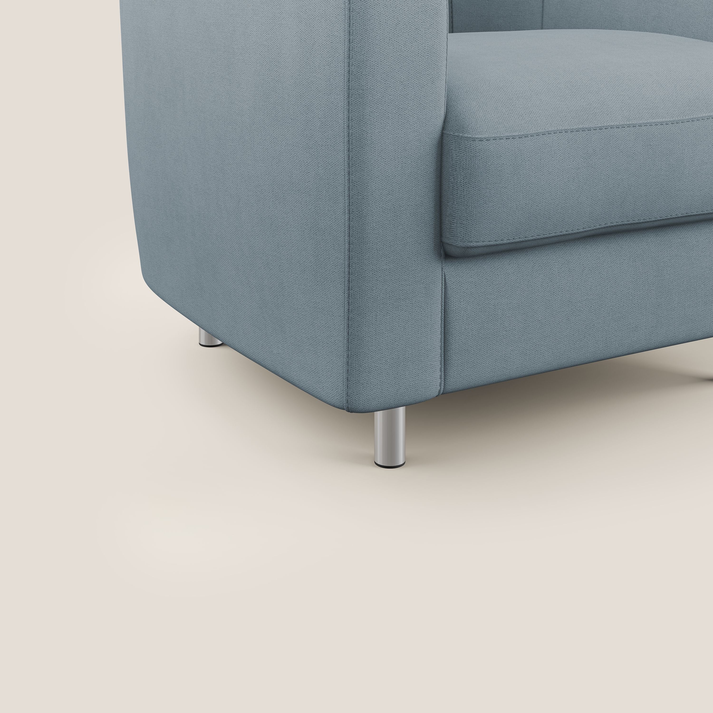 Primo piano della Poltroncina Sally in tessuto morbido impermeabile T02 carta da zucchero di Divani.Store, che mostra il tessuto liscio azzurro, parte del cuscino di seduta e del bracciolo, e le gambe cilindriche in metallo su sfondo beige.