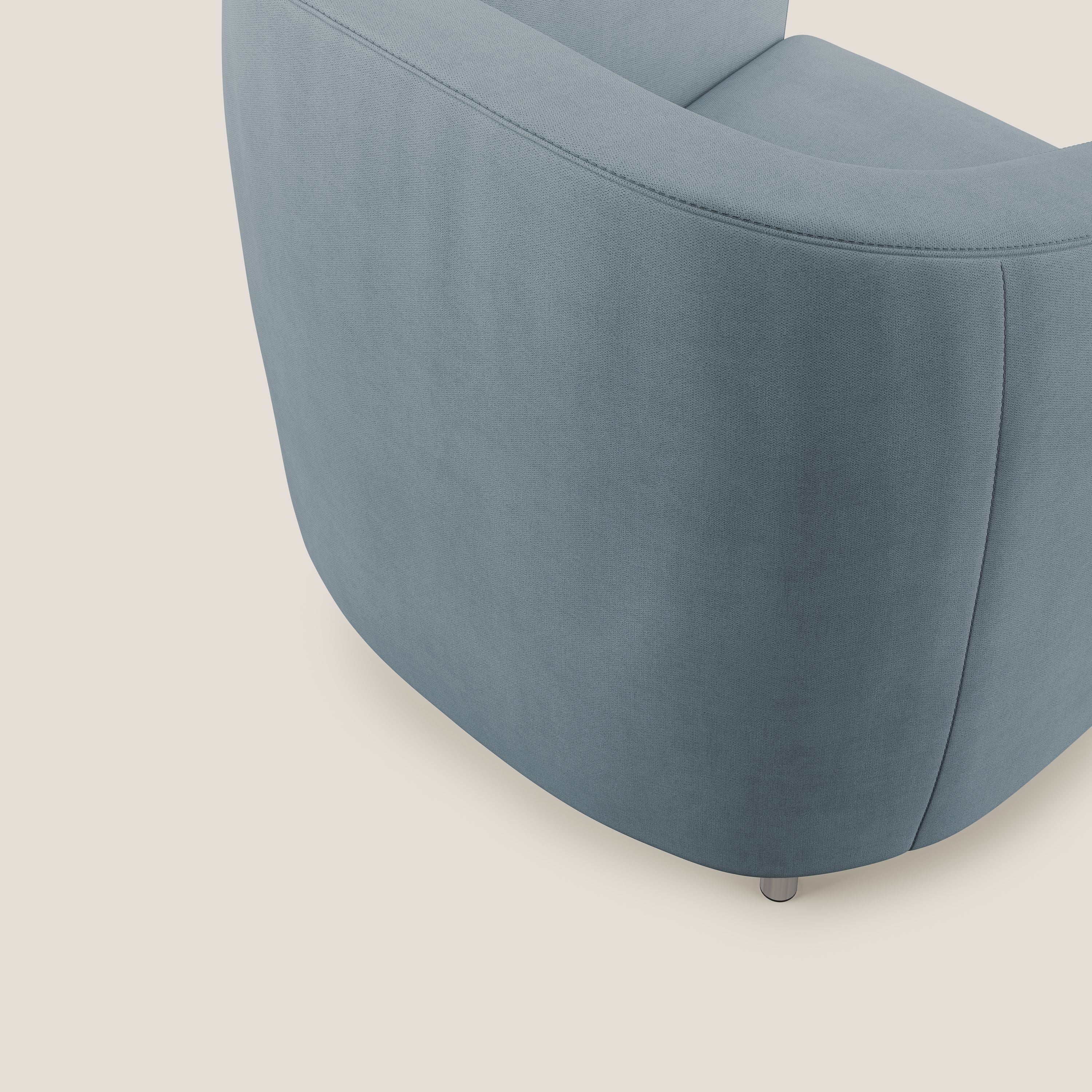 Primo piano della Poltroncina Sally di Divani.Store in morbido tessuto impermeabile T02 carta da zucchero, caratterizzata da curve moderne e piccole gambe nere, su sfondo beige chiaro.