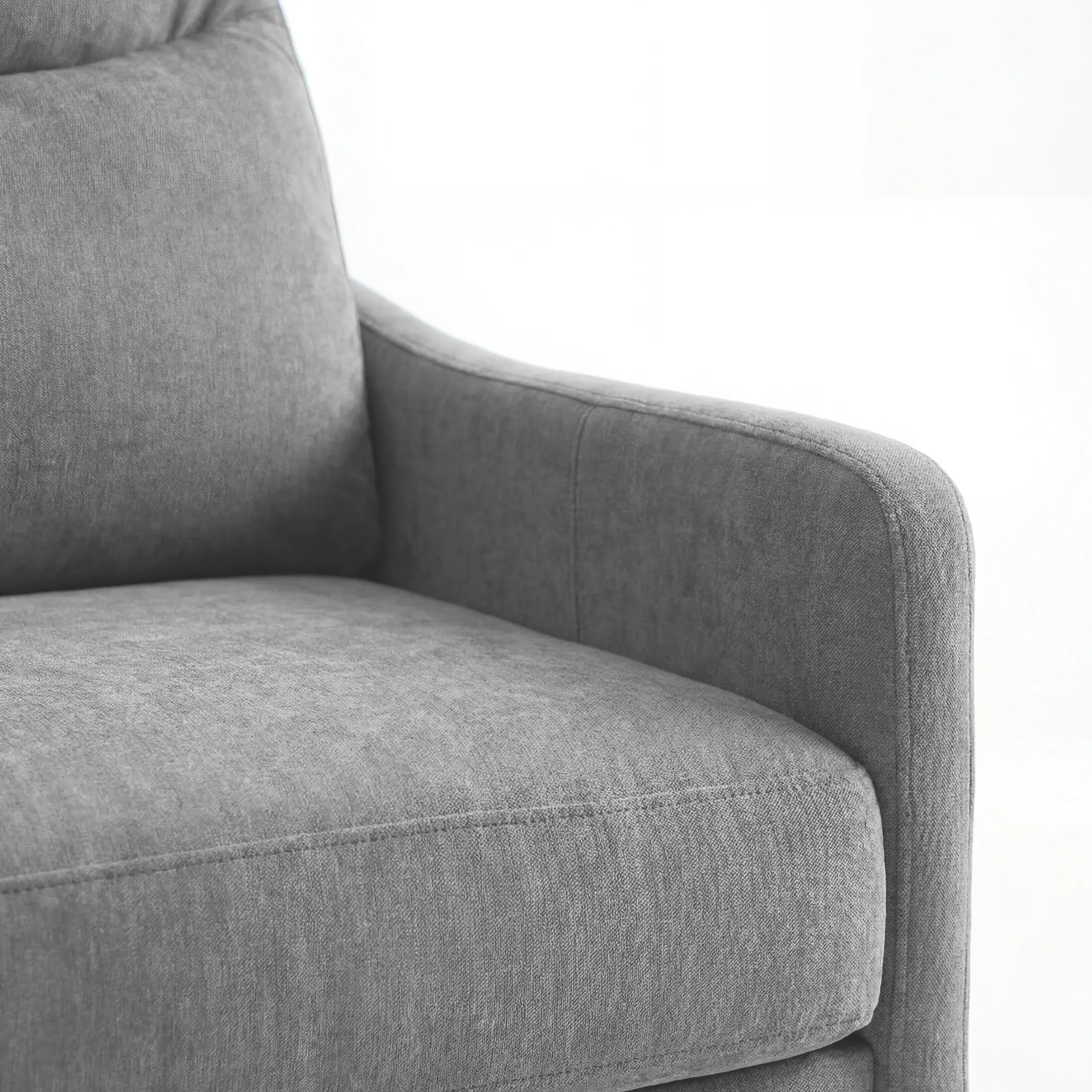 Primo piano del bracciolo e della seduta del divano letto a 3 posti Lodovico di Divani.Store, realizzato con un morbido tessuto antimacchia certificato Oeko-Tex, imbottitura soffice e un bracciolo leggermente ricurvo su uno sfondo bianco.