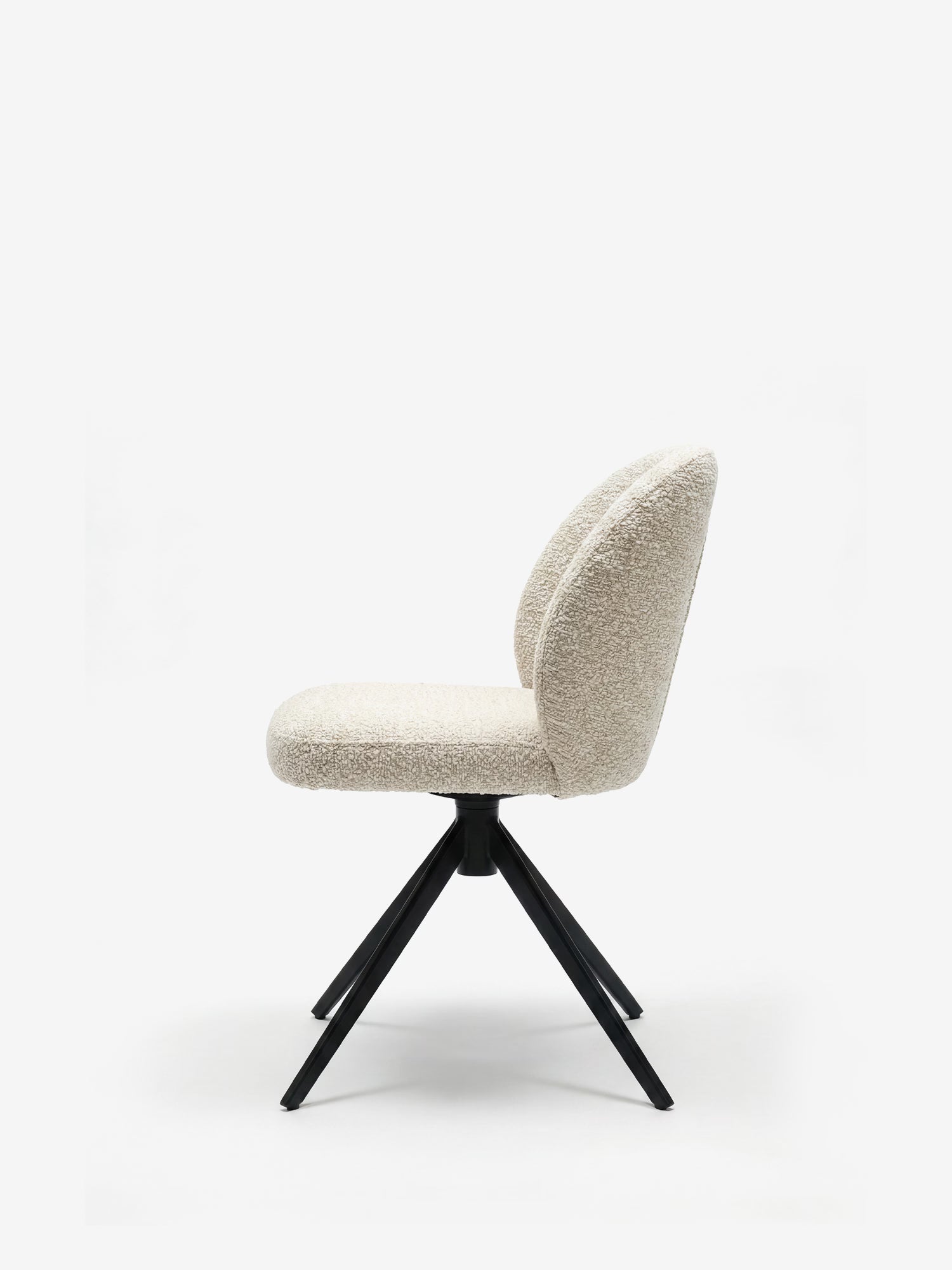 Vista laterale della sedia imbottita Alba di Divani.Store, caratterizzata da seduta e schienale arrotondati in tessuto effetto cotone certificato OEKO-TEX® color bianco sporco, con quattro gambe angolate in metallo nero su una base a stella su sfondo bianco.