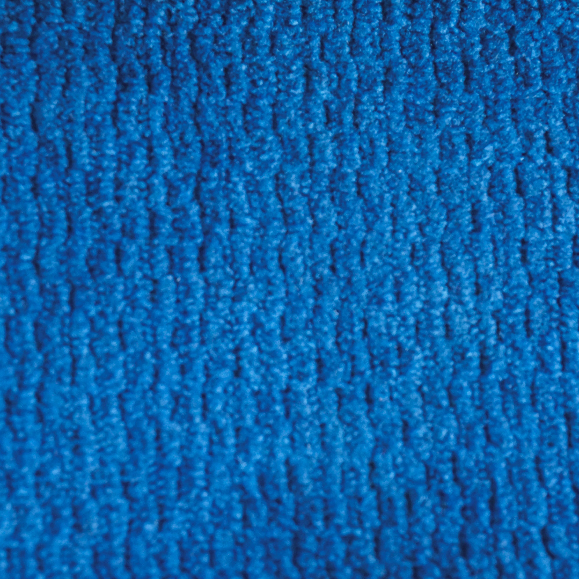 Primo piano della Personalizzazione di Divani.Store in T32: un tessuto blu morbido e spesso con un motivo ripetitivo e leggermente in rilievo. L'illuminazione accentua la ricchezza della trama e dell'intreccio di questo tessuto pregiato.