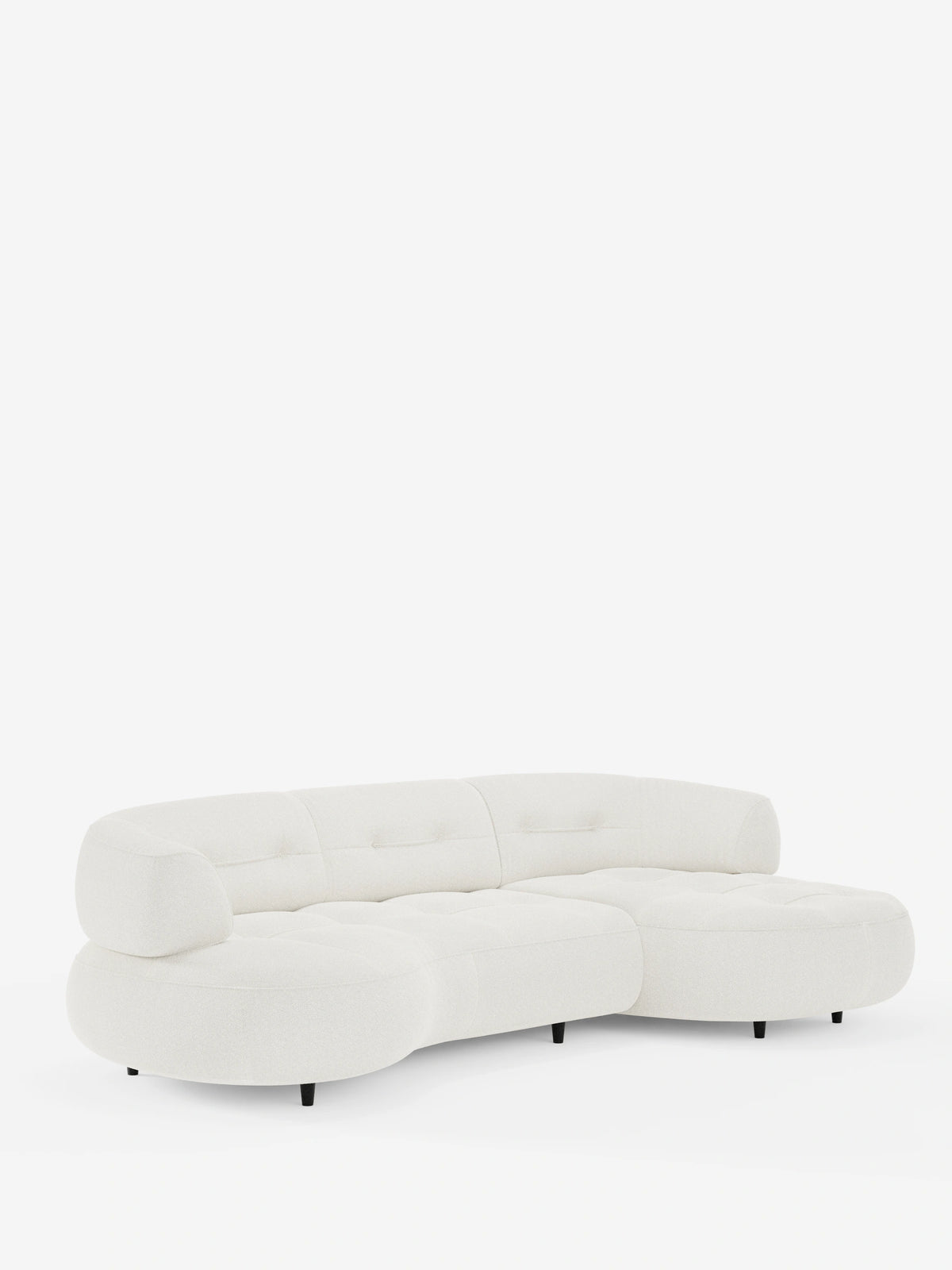 Un divano angolare Croissant color crema dal design a forma di fagiolo e schienali scorrevoli in morbido tessuto effetto cotone smacchiabile T33, caratterizzato da una silhouette curva e organica con cuscini trapuntati su gambe basse, scure e affusolate.