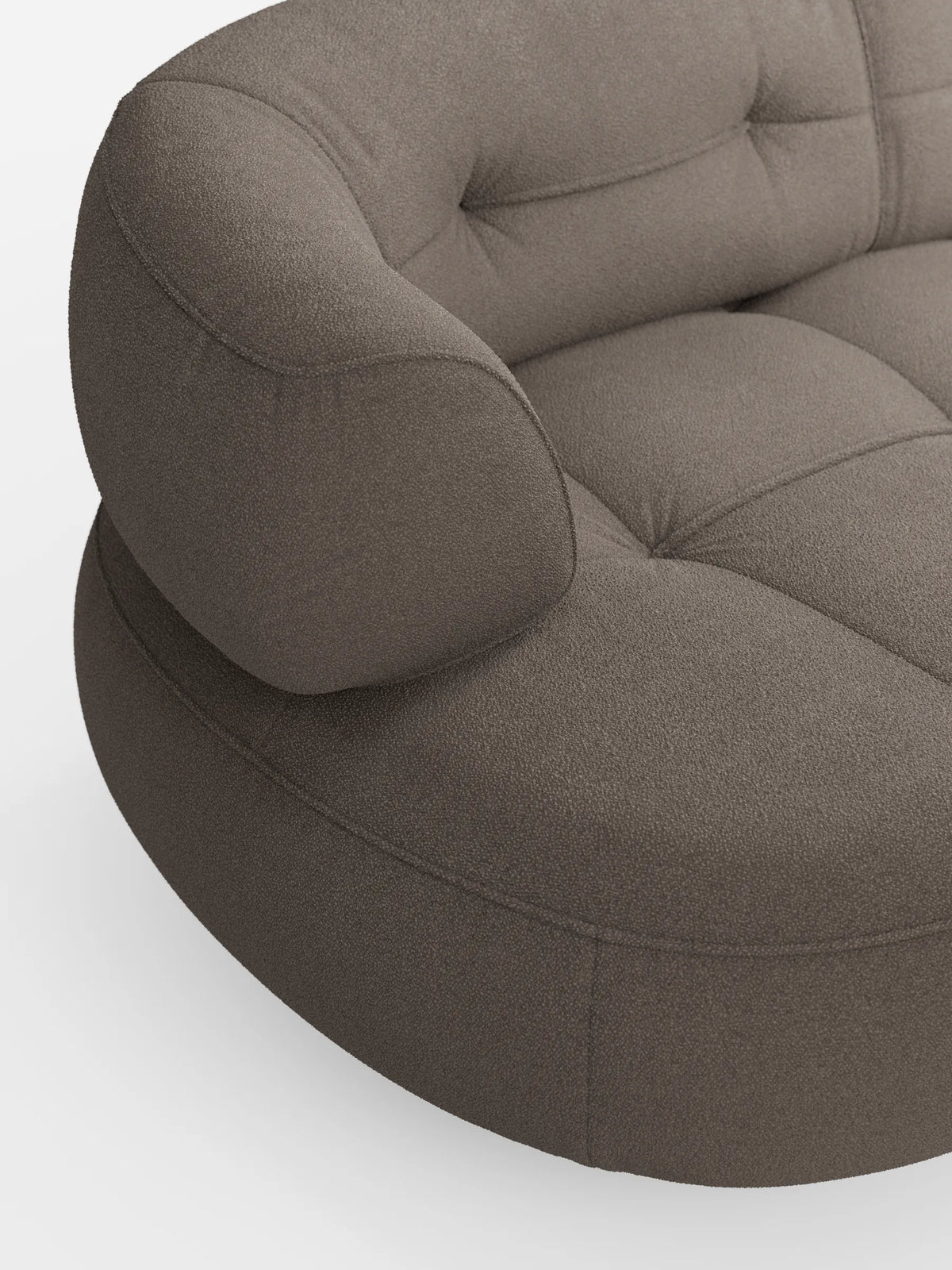 Un divano angolare Croissant di colore marrone scuro, dal design a forma di fagiolo e con schienali scorrevoli in morbido tessuto effetto cotone smacchiabile T33, caratterizzato da una profonda trapuntatura, braccioli arrotondati e uno sfondo grigio chiaro.