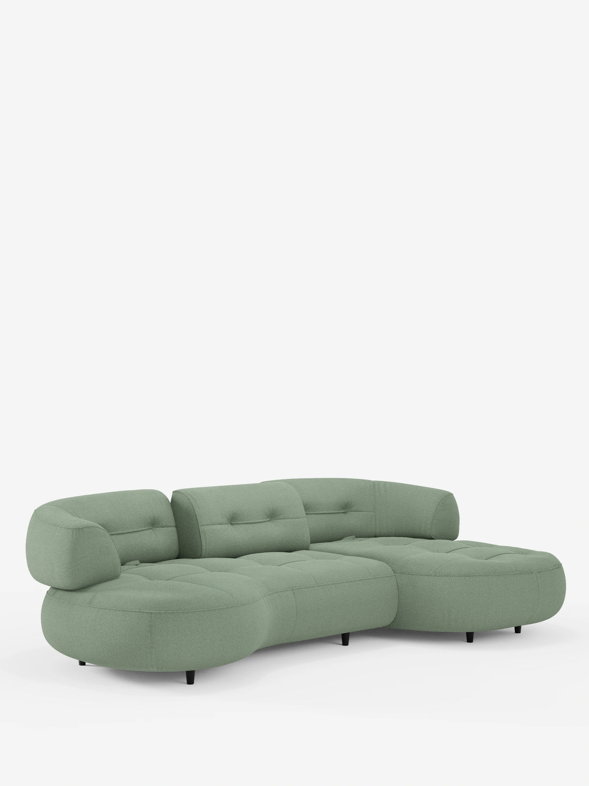 Un divano angolare Croissant dal design a forma di fagiolo e schienali scorrevoli in morbido tessuto effetto cotone lavabile T33: un divano componibile color verde salvia, a forma di fagiolo, dal design ribassato e trapuntato, con bordi arrotondati e sottili piedini neri.