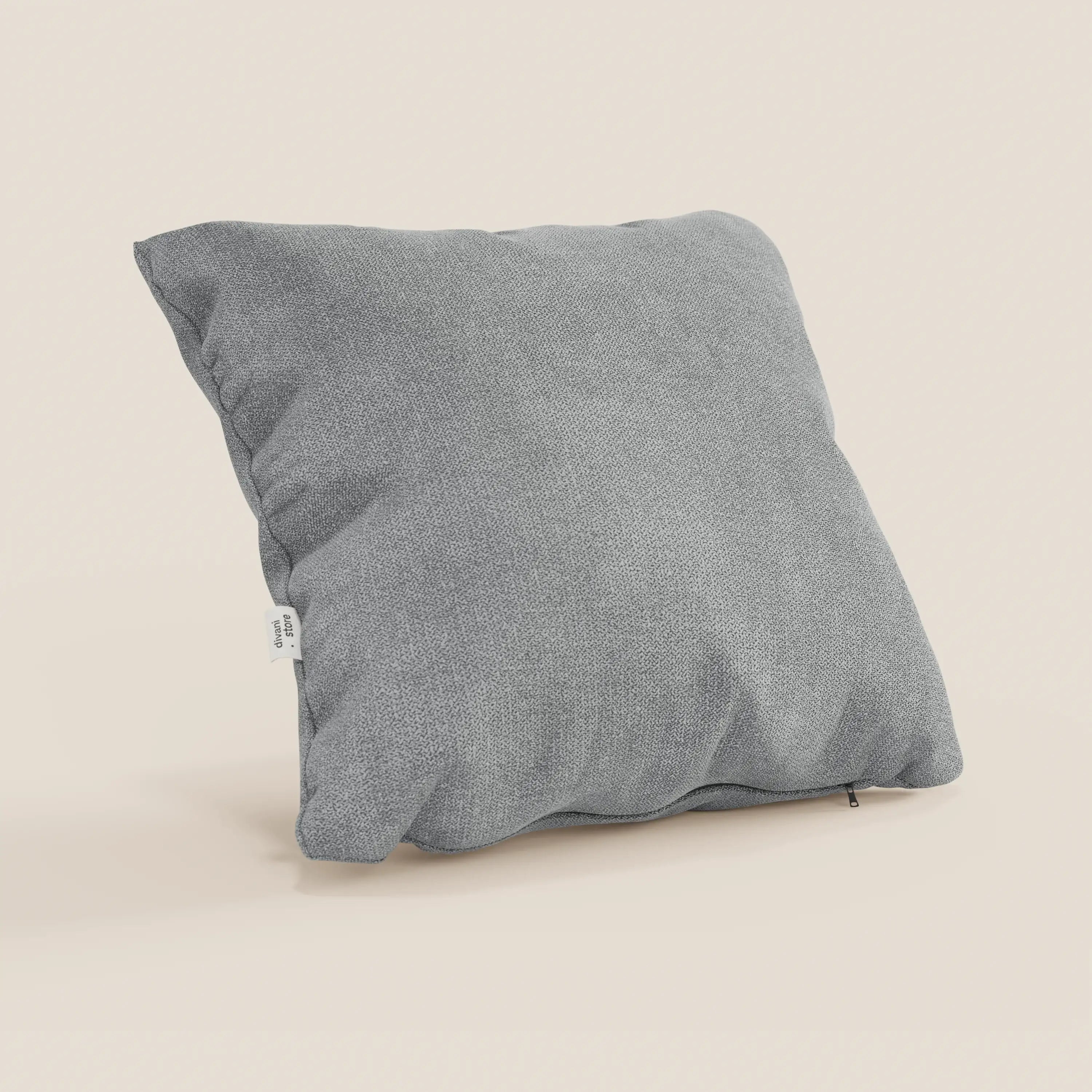 Il cuscino Destiny di Divani.Store, 45x45 cm, in morbido tessuto impermeabile T02 grigio chiaro con una sottile trama intrecciata e una targhetta laterale bianca, si staglia su uno sfondo beige chiaro. Federa lavabile.
