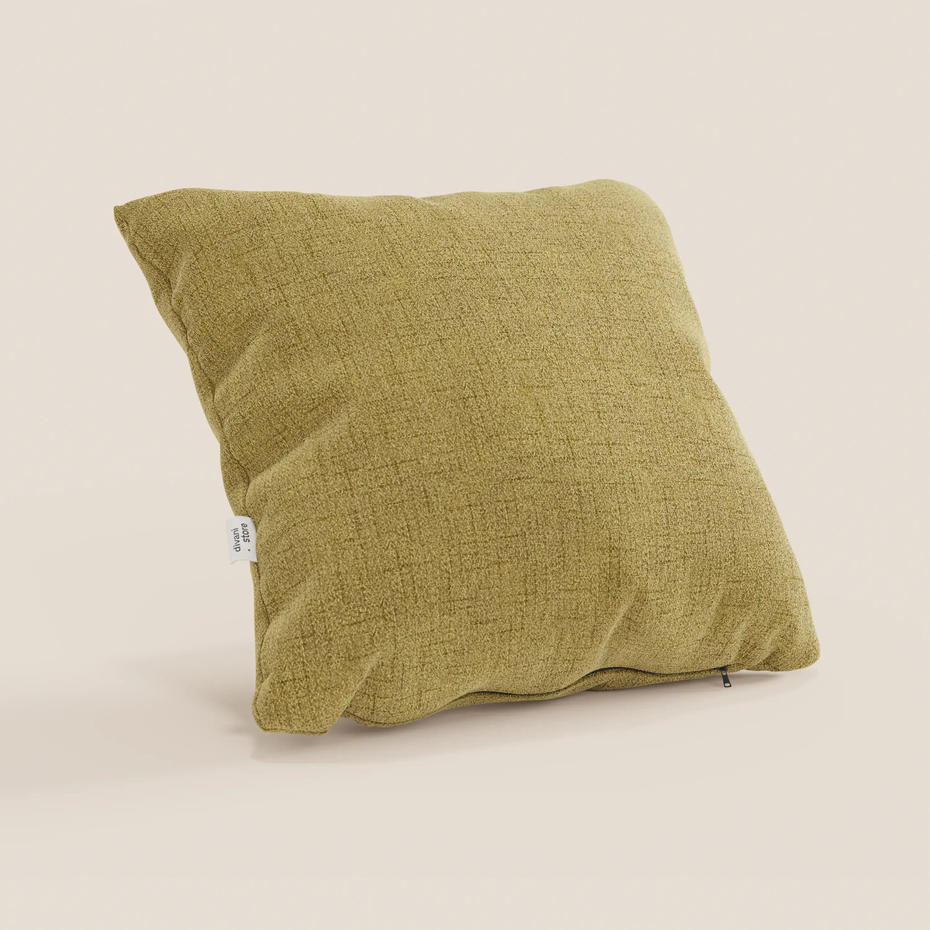 Un cuscino Felis di Divani.Store, in morbido tessuto impermeabile T03 giallo, poggia su una superficie beige chiaro. Presenta un aspetto strutturato e leggermente stropicciato, uno sfondo bianco sporco, un'etichetta in tessuto bianco e una cerniera a vista.