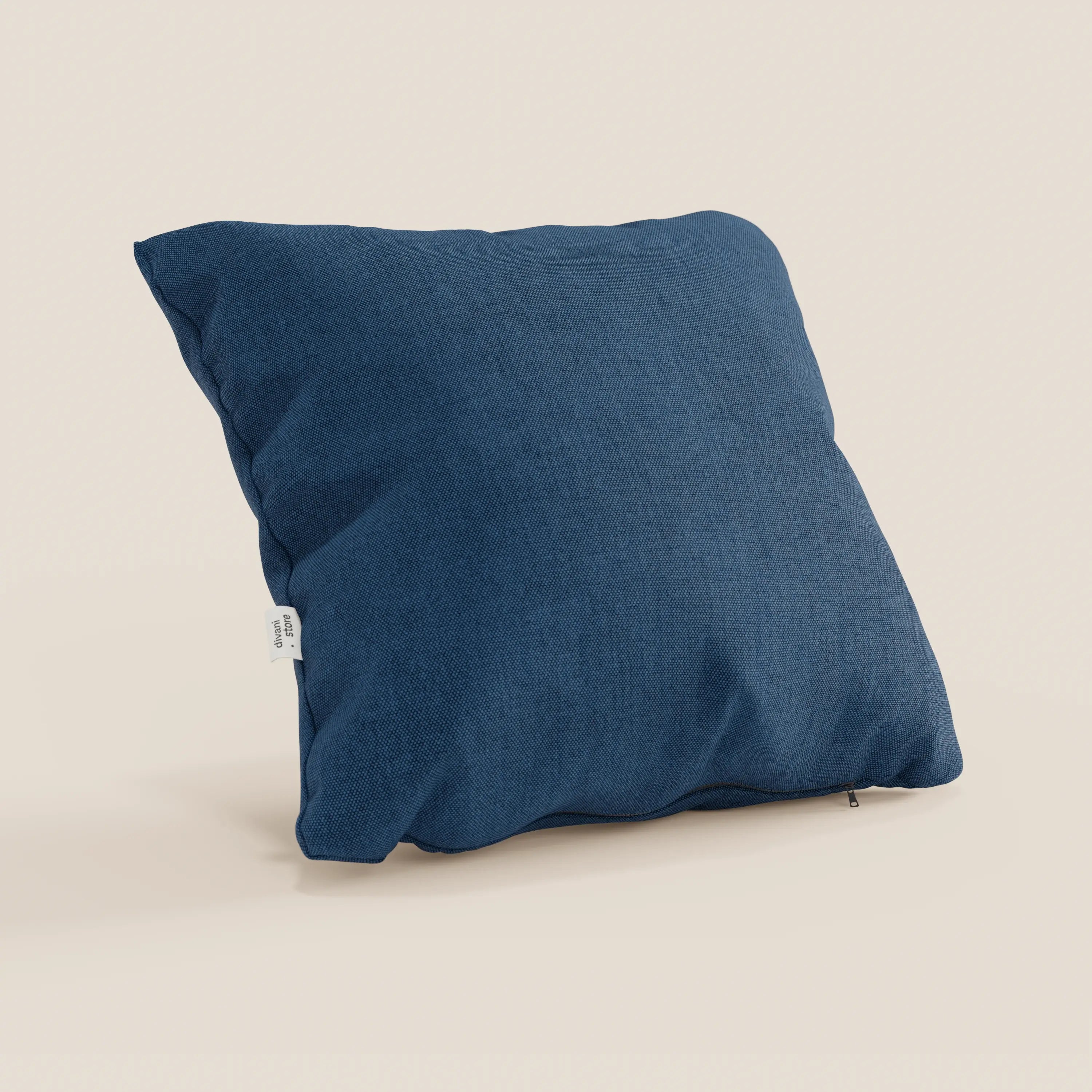 Il cuscino Honey di Divani.Store, in tessuto blu simil cotone impermeabile T13 (45x45), è posizionato in verticale su uno sfondo bianco sporco, con una piccola etichetta bianca sul lato e una cerniera a vista per la fodera lavabile.