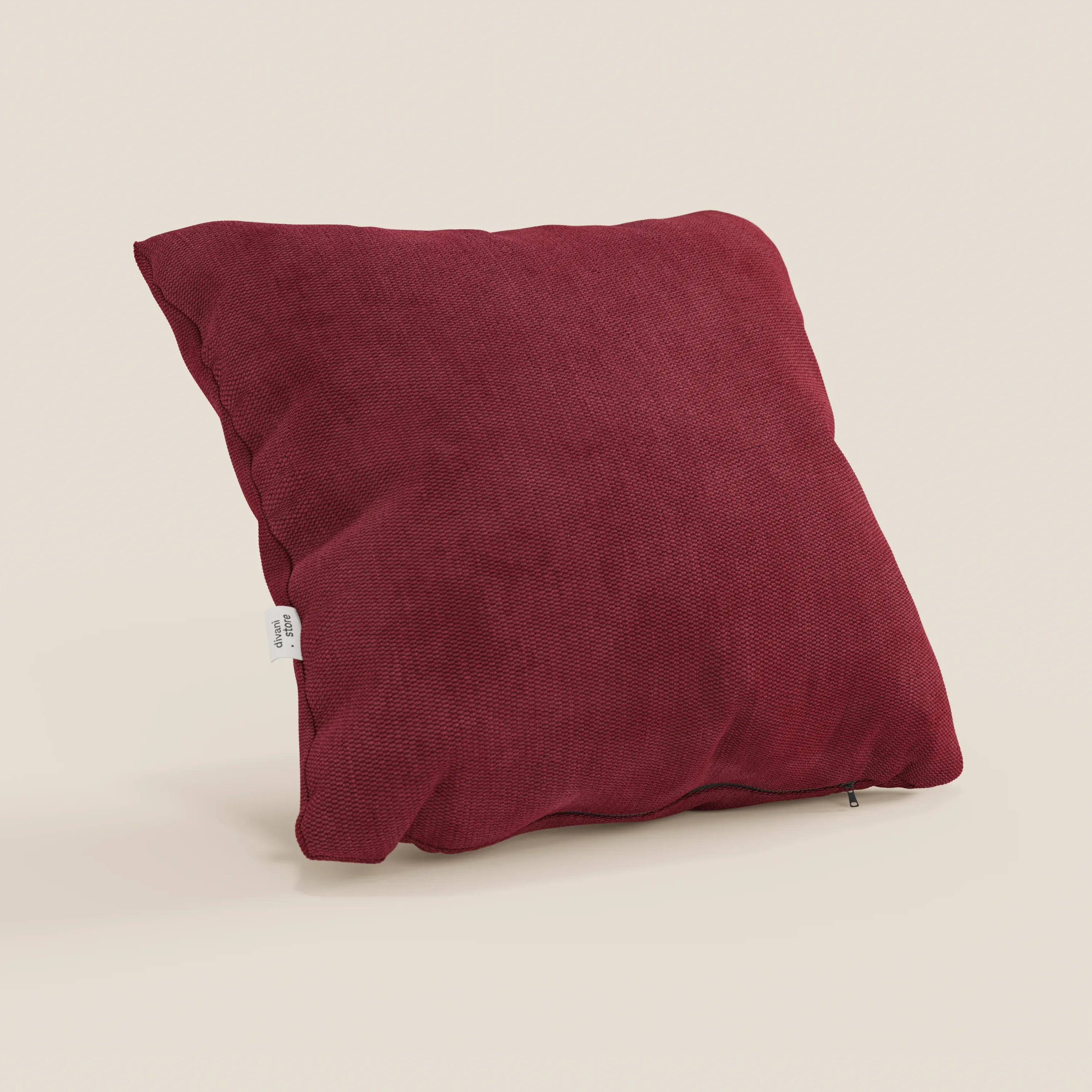 Il cuscino Miami di Divani.Store, qui presentato in rosso intenso (T14 rosso), è caratterizzato da un tessuto morbido e impermeabile e da una cerniera laterale. In mostra su uno sfondo beige chiaro con etichetta bianca visibile.