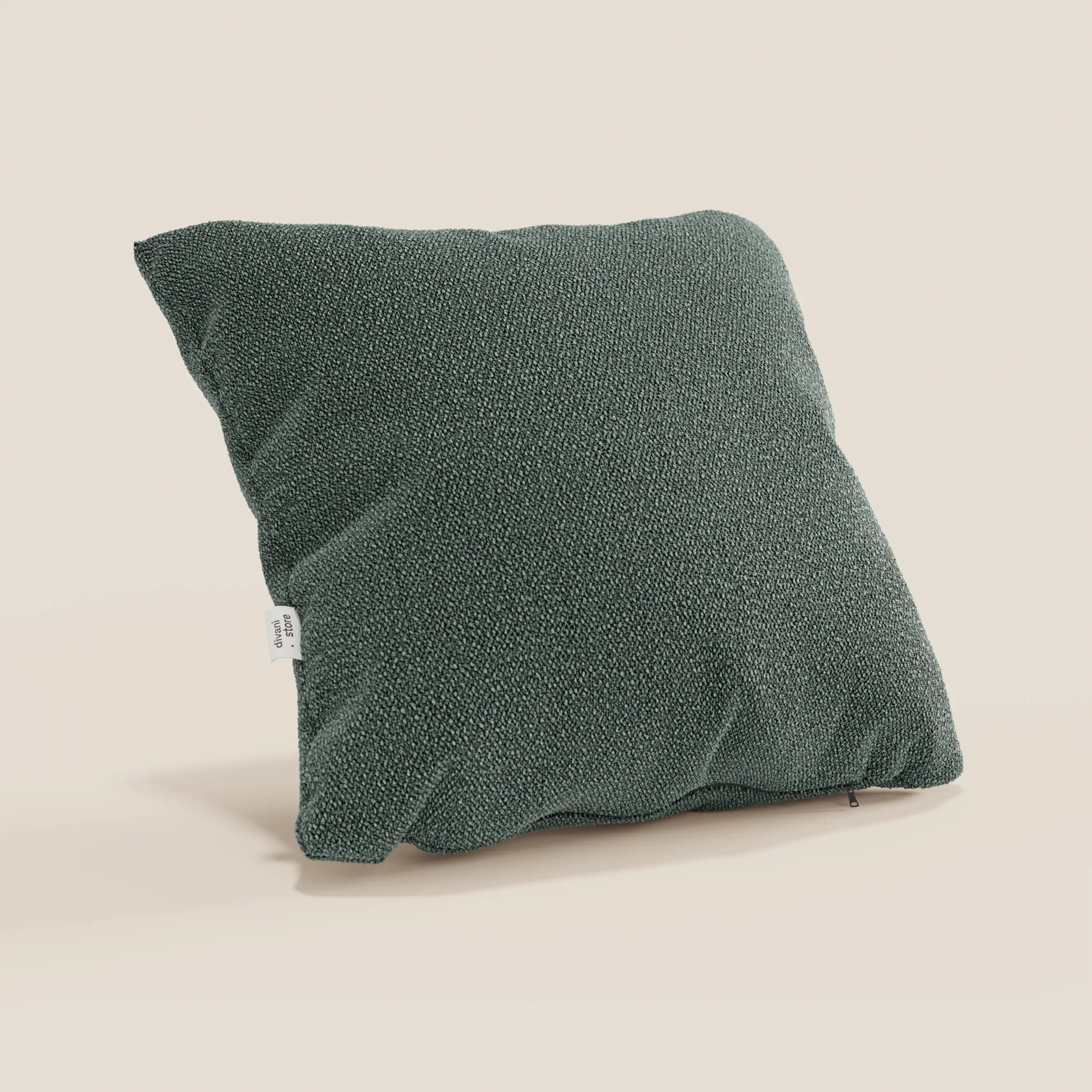 Un cuscino Lambada quadrato verde scuro di Divani.Store è presentato su uno sfondo beige chiaro. Realizzato in tessuto T33 naturale, antimacchia e impermeabile, ha una superficie morbida che lascia intravedere un'imbottitura in peluche e presenta una piccola etichetta laterale bianca.