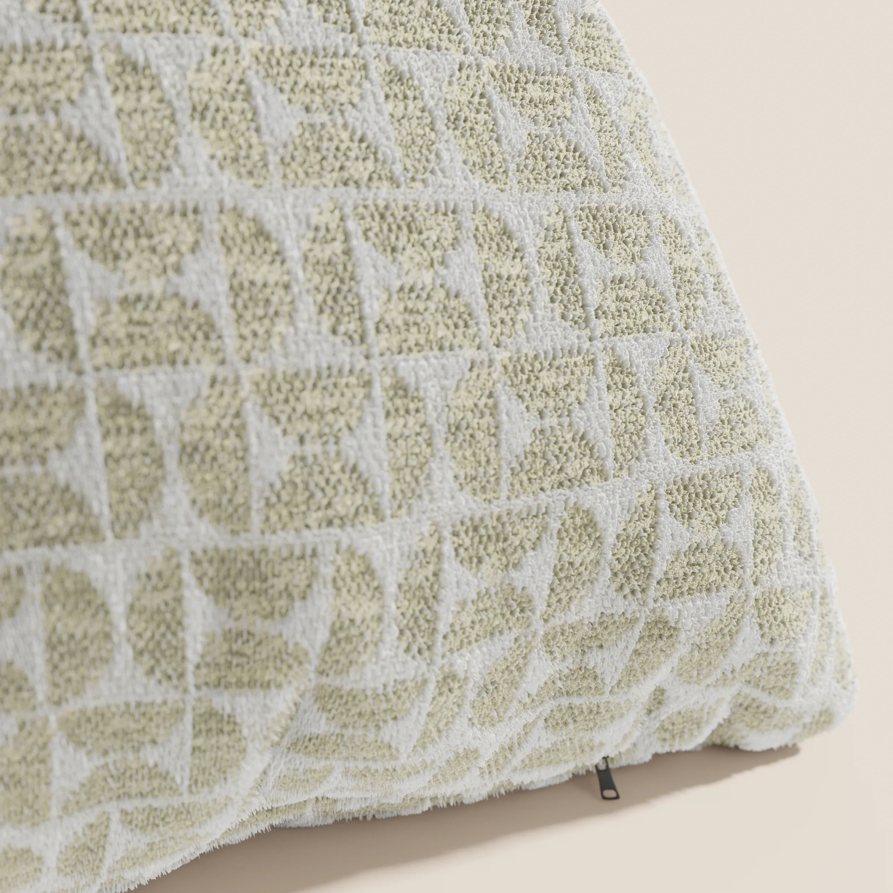 Primo piano del cuscino Naxos Decoro 45x45 in lino di Divani.Store, caratterizzato da un elegante motivo geometrico trapuntato nei toni del beige chiaro e del bianco sporco, con un piccolo tirazip nero vicino al bordo inferiore su uno sfondo beige chiaro.
