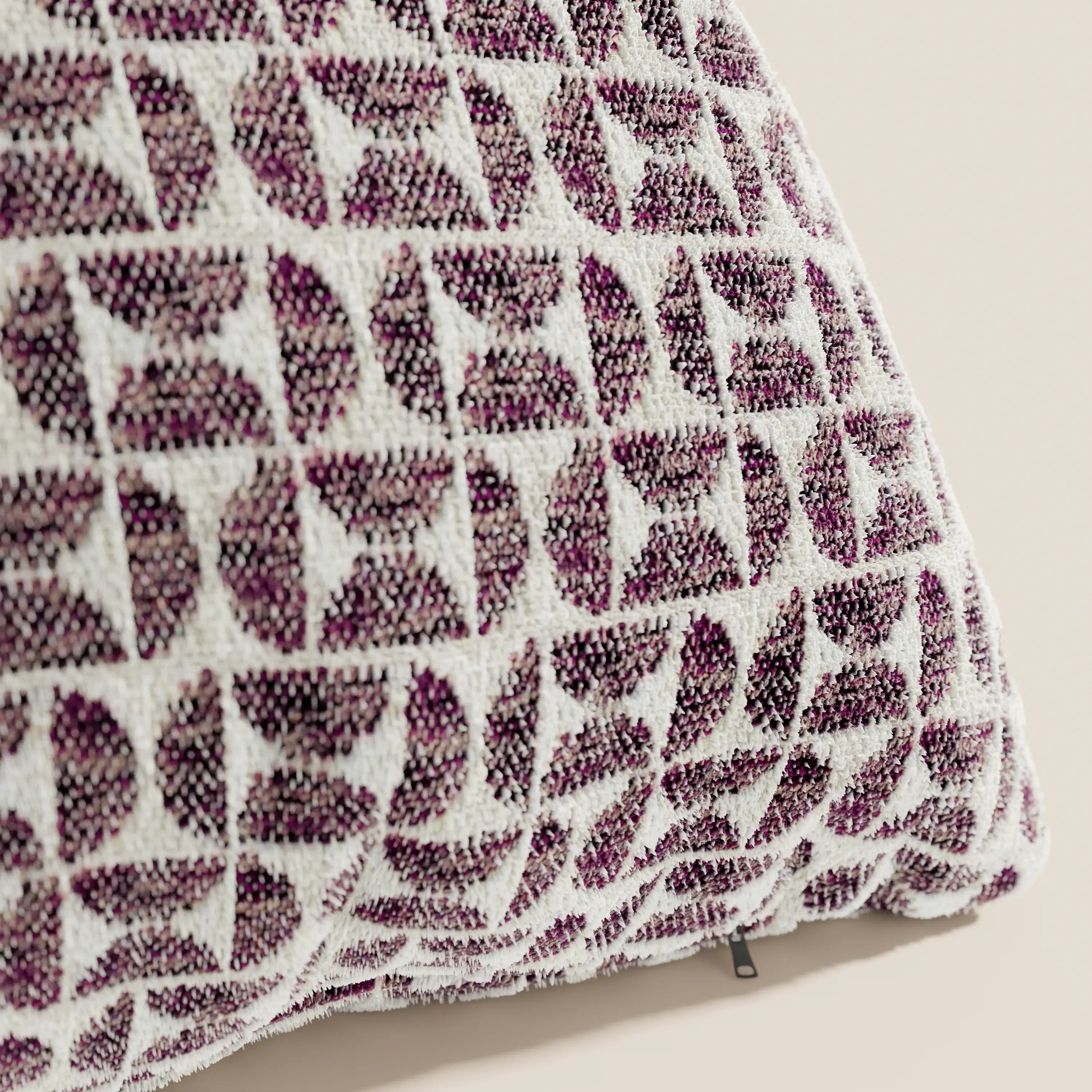Primo piano del cuscino Naxos Decoro 45x45 in lino di Divani.Store, caratterizzato da un motivo moderno e geometrico nei toni del viola scuro e del bianco con forme intrecciate, una texture elegante e una cerniera discreta sul bordo.