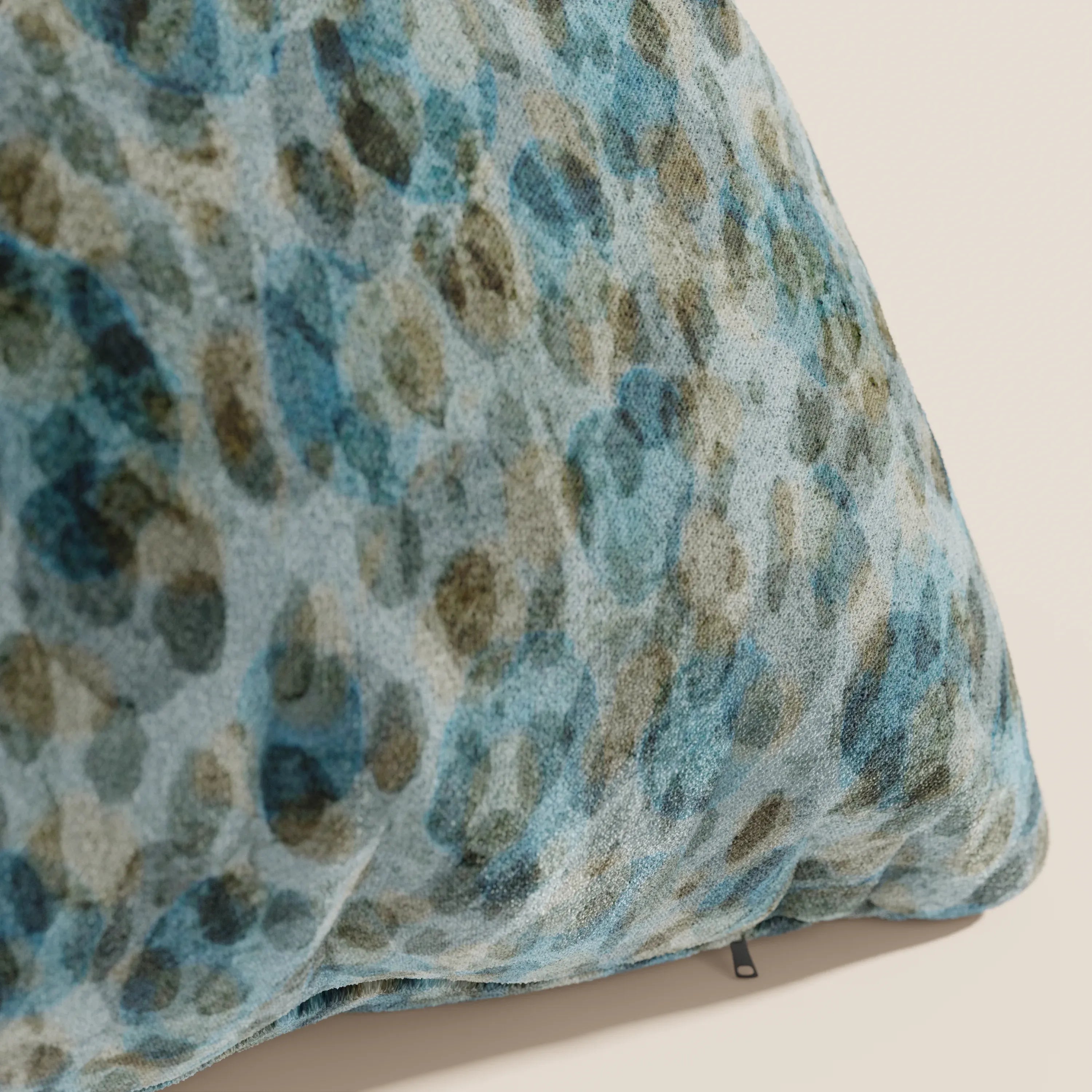 Un primo piano dei cuscini Brush di Divani.Store, 45x45 cm in verde acqua impermeabile velluto. Il cuscino, morbido e strutturato, è perfetto per i cuscinetti decorativi lavabili e presenta una piccola etichetta nera sulla cucitura.