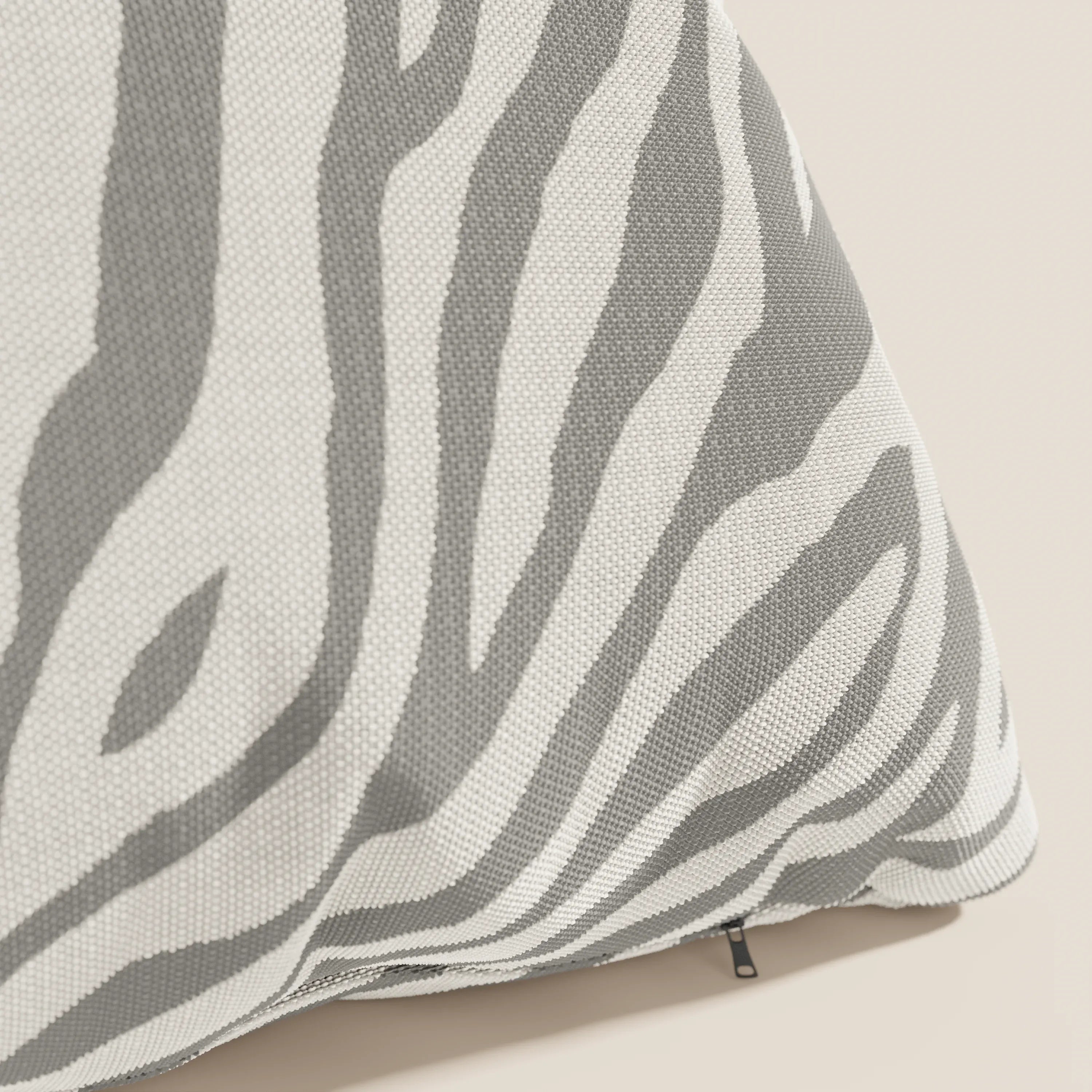 Primo piano di Stripe cuscini geometrici in tessuto Idrorepellente di Divani.Store, in grigio e bianco. Il cuscino presenta una trama intrecciata, una piccola cerniera nera e spicca su uno sfondo beige chiaro. Disponibile in vari colori.