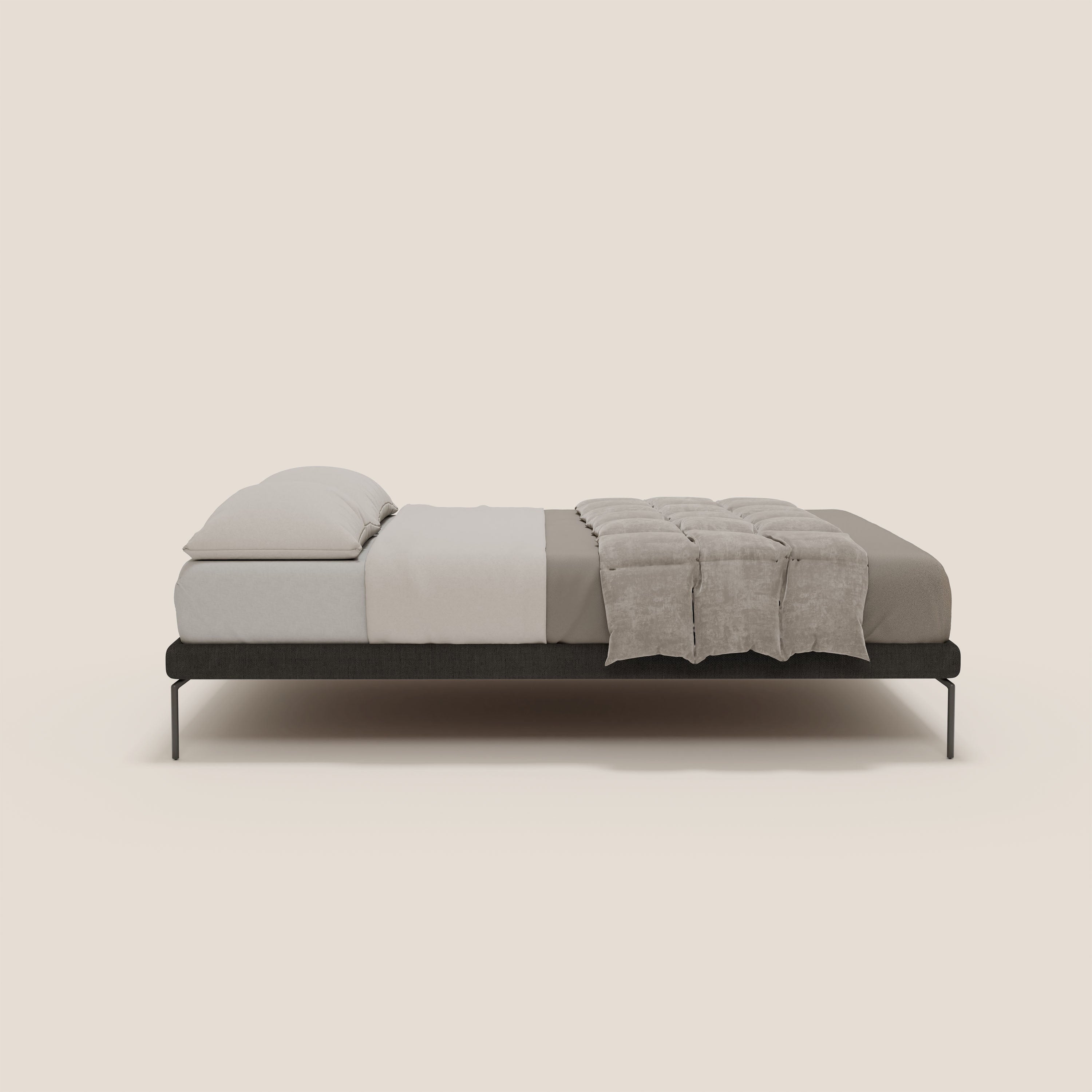 Un letto minimalista di Letti.store con Ring sommier sfoderabile in tessuto impermeabile T14 antracite, gambe alte 24 cm, materasso grigio chiaro, due cuscini bianchi impilati e un piumino beige su sfondo bianco sporco per un raffinato look italiano.