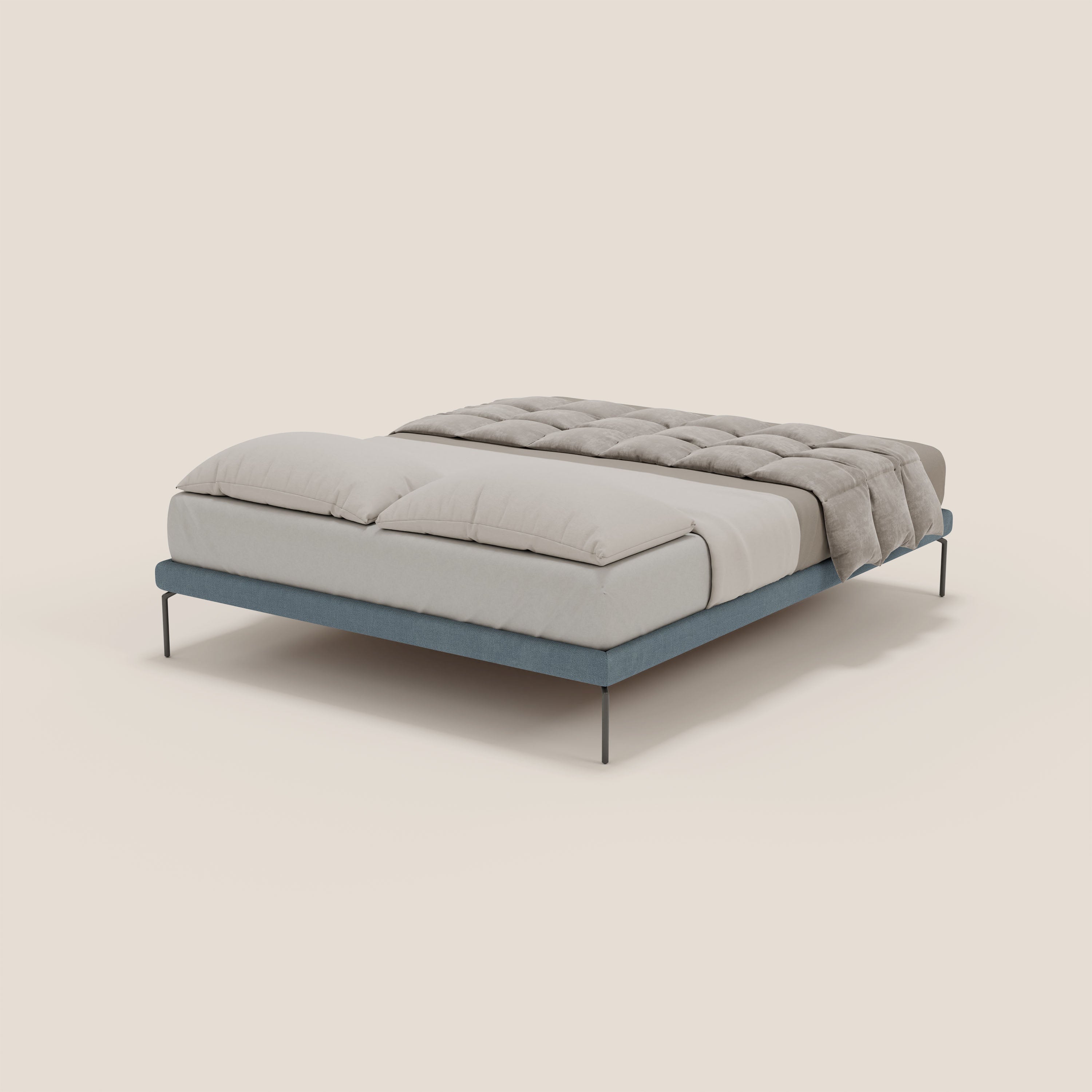 Il sommier sfoderabile Ring di Letti.store è caratterizzato da gambe alte 24 cm e da un tessuto impermeabile T14 blu carta da zucchero, abbinato a lenzuola bianche, grandi cuscini e un piumone grigio chiaro: una moderna eleganza italiana su uno sfondo beige.