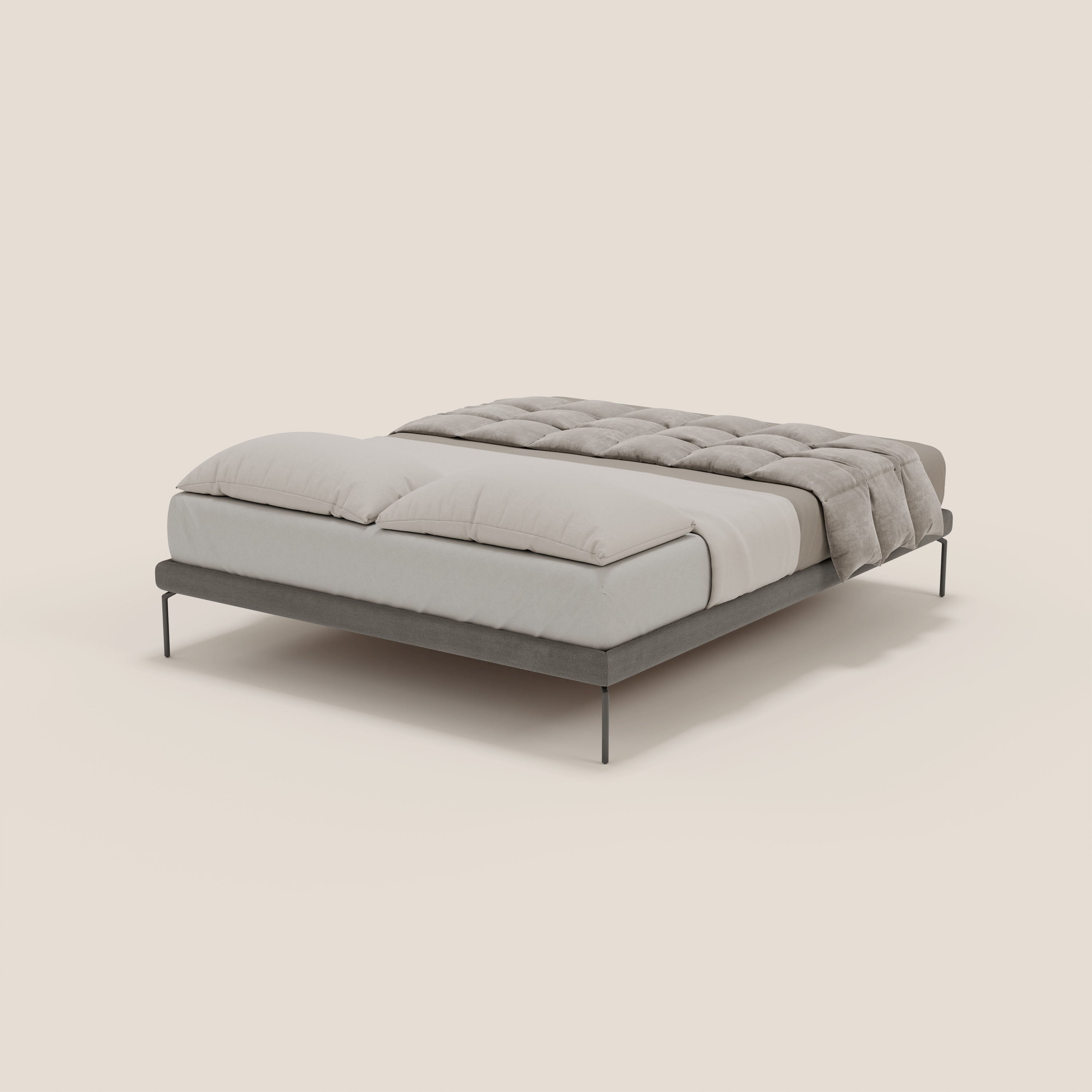 Il sommier sfoderabile Ring di Letti.store, con gambe alte 24 cm e tessuto impermeabile T14 grigio, è caratterizzato da un minimalismo italiano con un lenzuolo matrimoniale grigio chiaro, due grandi cuscini e un piumone trapuntato su sfondo bianco sporco.