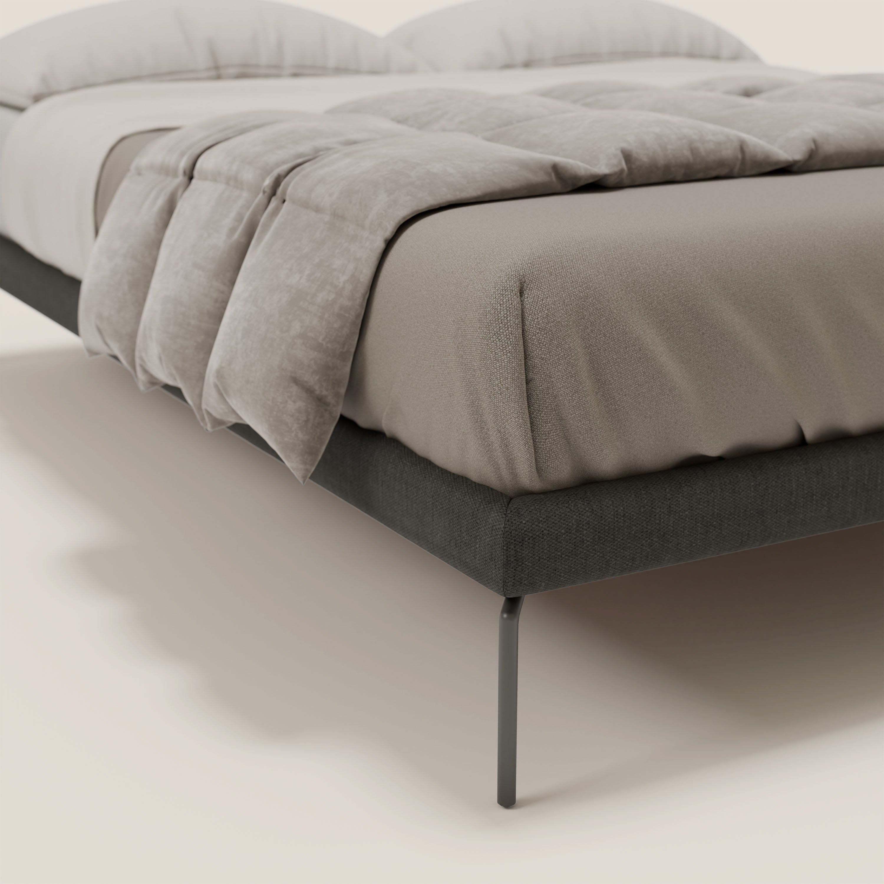 Primo piano del sommier sfoderabile Ring di Letti.store con gambe alte 24 cm in tessuto impermeabile T14 antracite, dal design italiano e dall'alta qualità, abbinato a lenzuolo beige e piumone marrone chiaro in un ambiente minimalista.