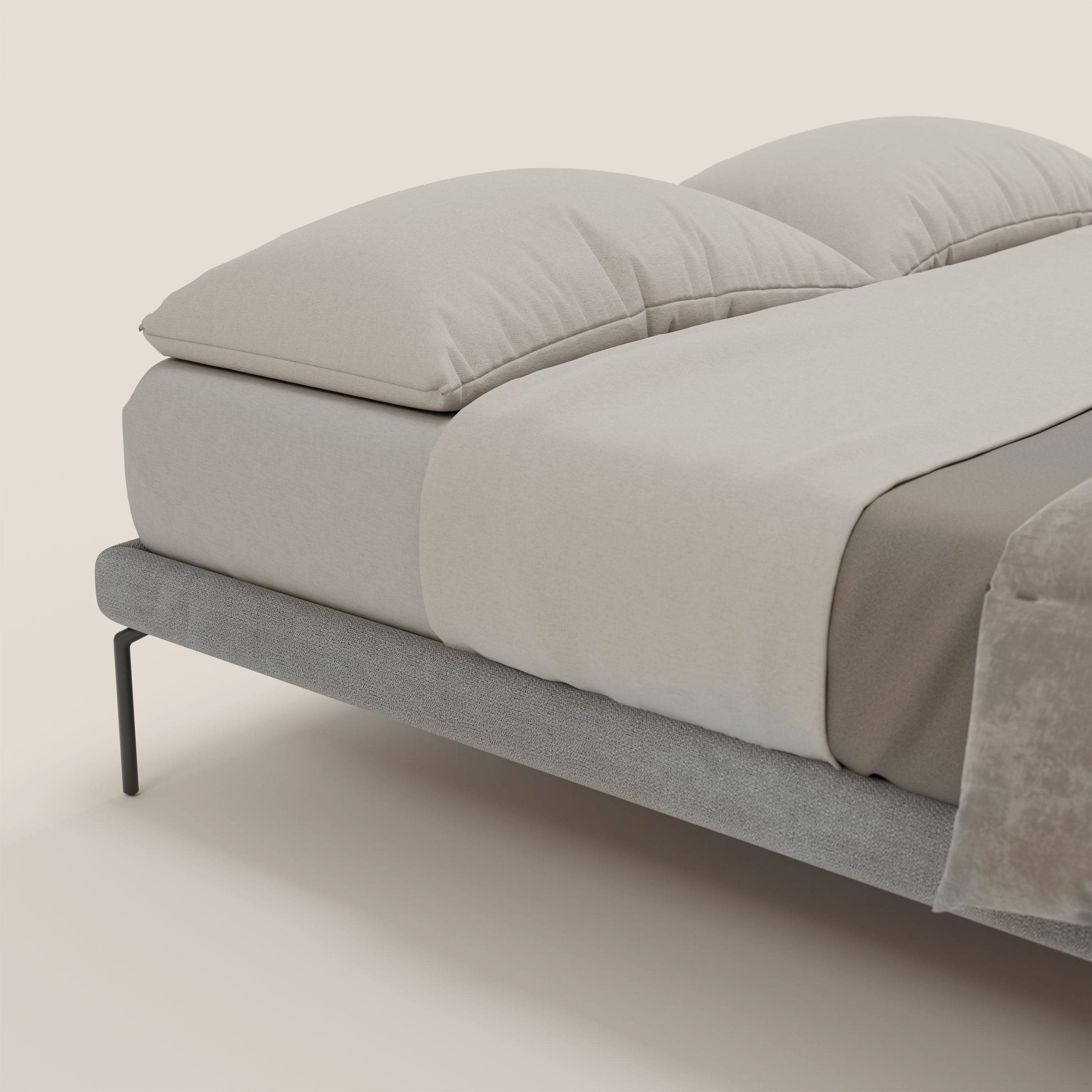 Letti.store Anello sommier sfoderabile con piedi alti 24 cm in tessuto impermeabile T14 grigio chiaro, abbinato a lenzuolo beige chiaro, due grandi cuscini coordinati, sopra-lenzuolo taupe e plaid morbido, su sfondo crema.
