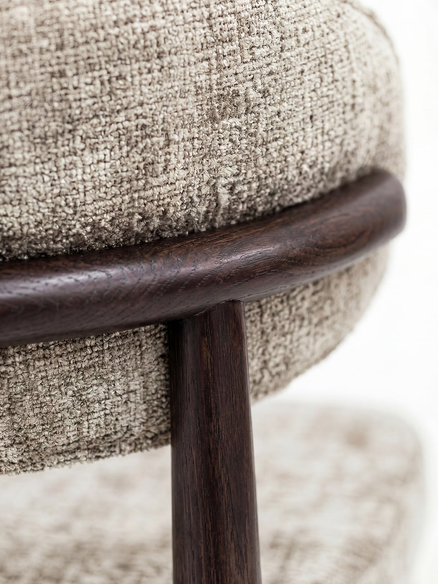 Primo piano della sedia Dafne firmata Divani.Store, caratterizzata da un rivestimento in tessuto chenille certificato OEKO-TEX® color beige e da una struttura in legno massello di wengé, che ne esalta la trama dettagliata e la finitura liscia.