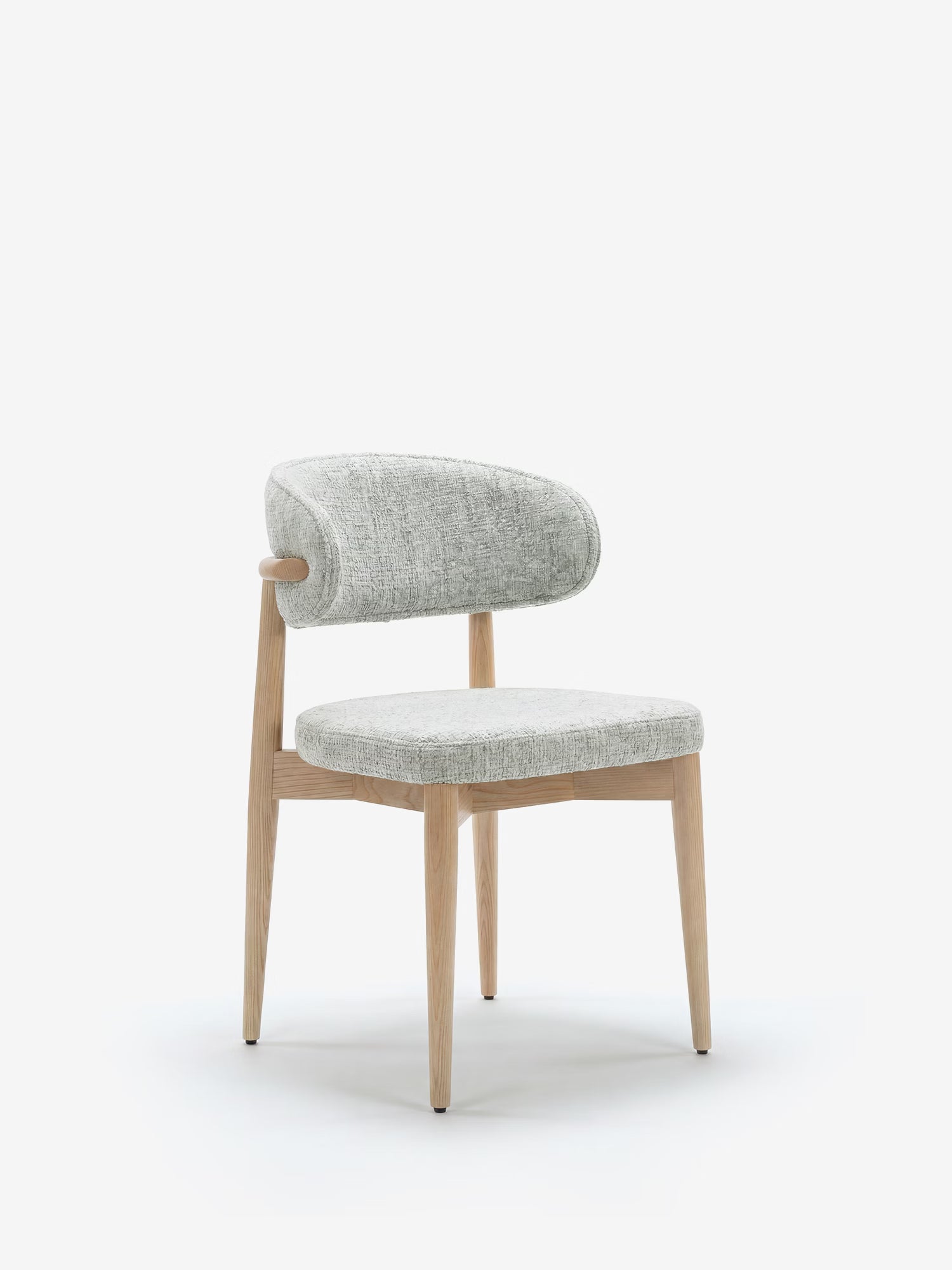 La sedia imbottita Dafne di Divani.Store presenta gambe e struttura in rovere naturale massiccio, con schienale curvo e imbottito e seduta imbottita in tessuto ciniglia certificato OEKO-TEX®, qui raffigurata in grigio chiaro testurizzato su uno sfondo bianco a tinta unita.