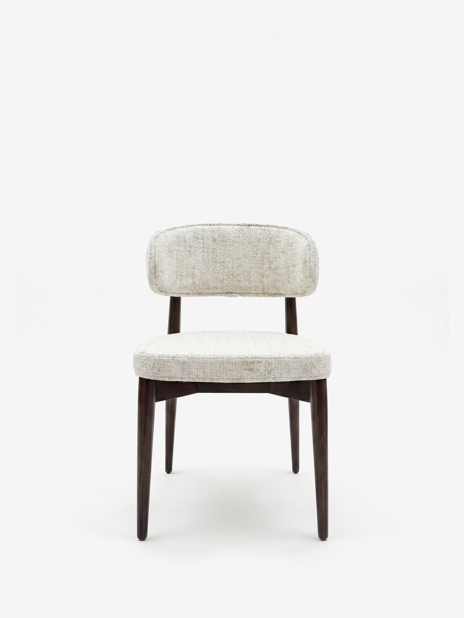 La sedia di design imbottita Dafne di Divani.Store presenta una seduta e uno schienale arrotondati in ciniglia beige chiaro testurizzata certificata OEKO-TEX®, quattro gambe leggermente inclinate in legno massello di wengé e senza braccioli, raffigurata su uno sfondo bianco a tinta unita.